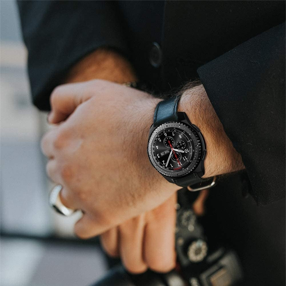 Eine Person trägt eine schwarze Smartwatch mit schwarzem Lederarmband. Das Zifferblatt zeigt die Uhrzeit und das Datum an. Die Person trägt einen schwarzen Anzug.