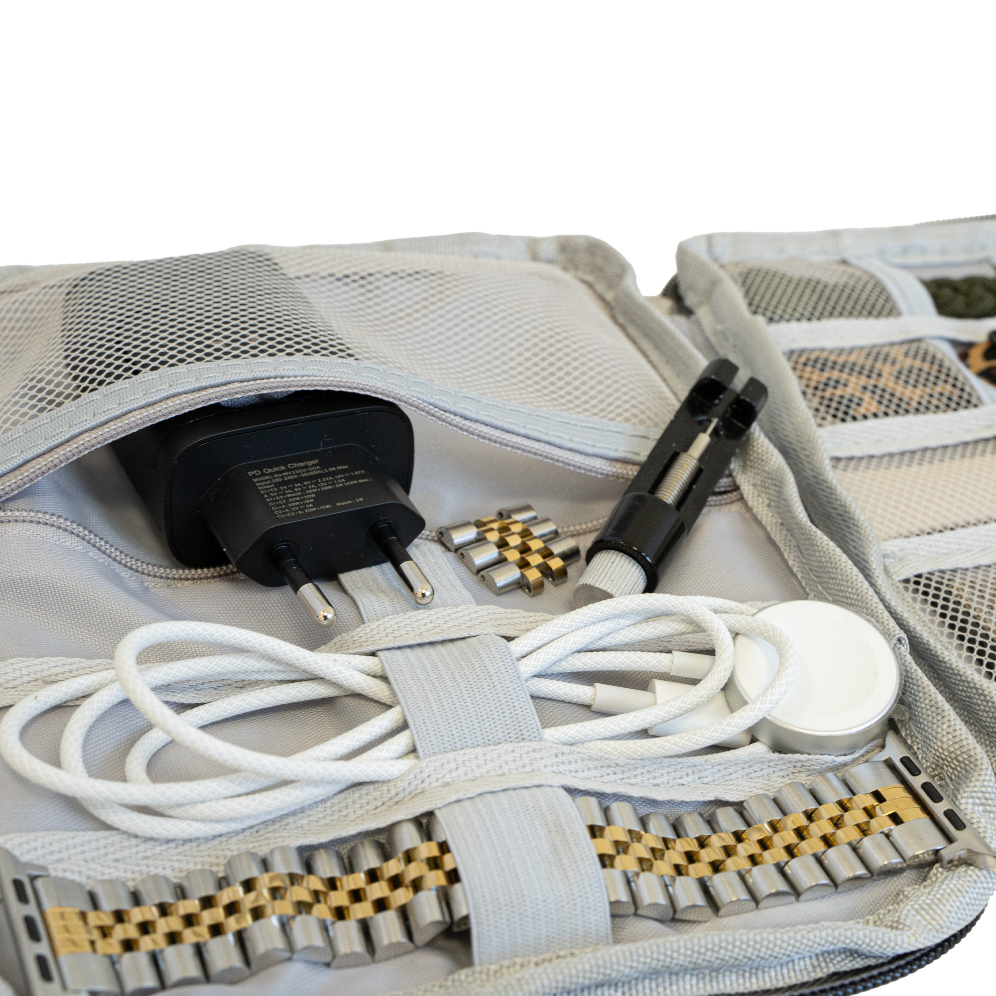 Graue Reisetasche mit Ladegerät, Uhrenarmband, Kabel, Uhrenladegerät und Werkzeug zur Armbandanpassung.