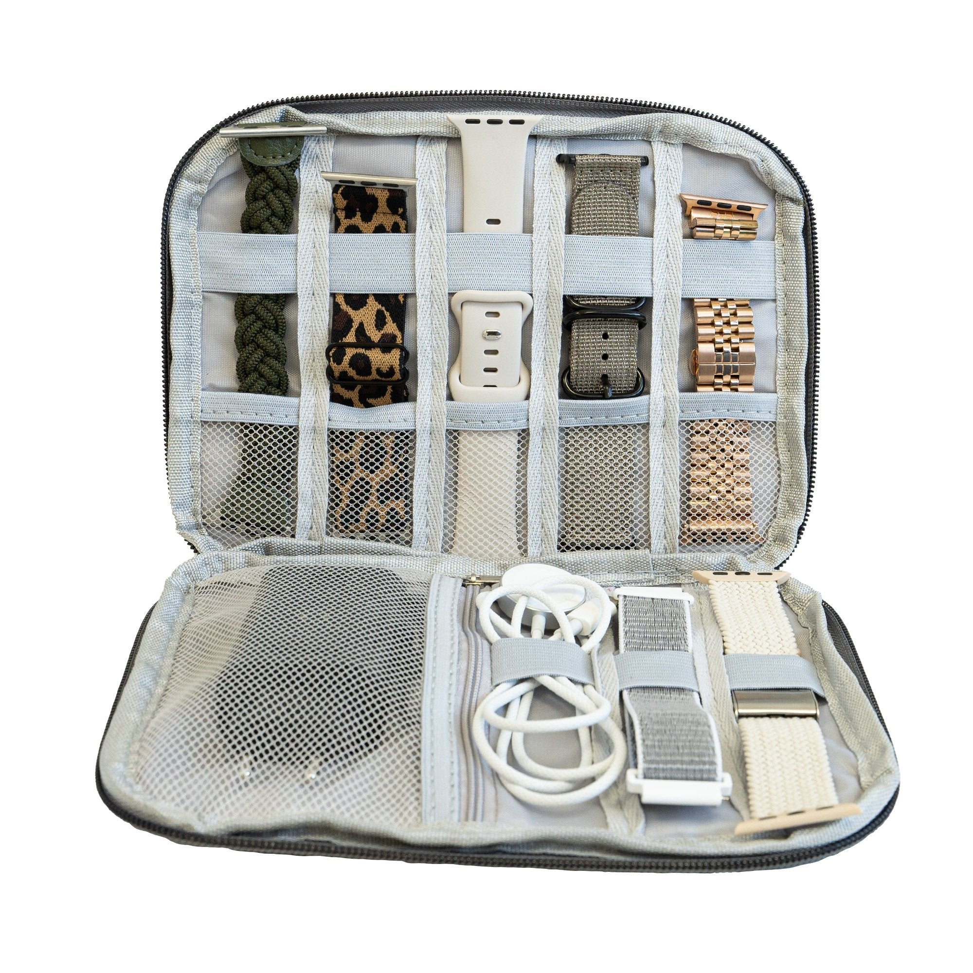 Offene Reisetasche mit verschiedenfarbigen Uhrenarmbändern und einem Ladekabel.