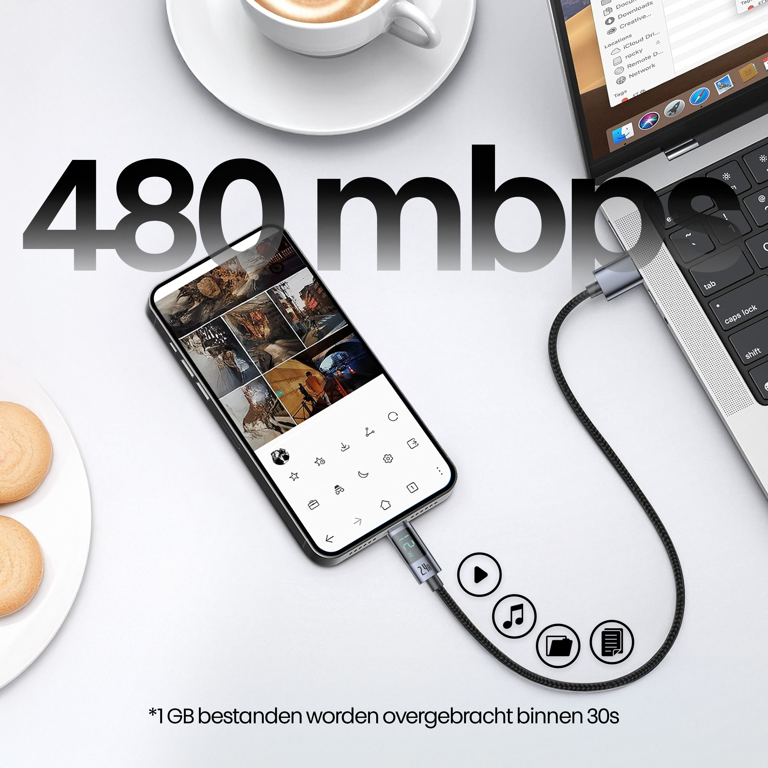 A phone connected to a laptop via a cable. A cup of coffee and cookies are on the table. The speed is 480mbps.