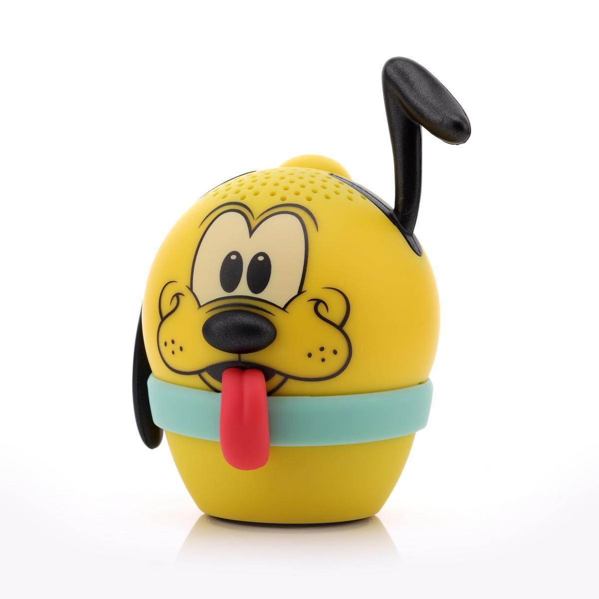 Un altavoz amarillo con forma de Pluto, con lengua roja, orejas negras y una banda azul. El altavoz está sobre un fondo blanco.