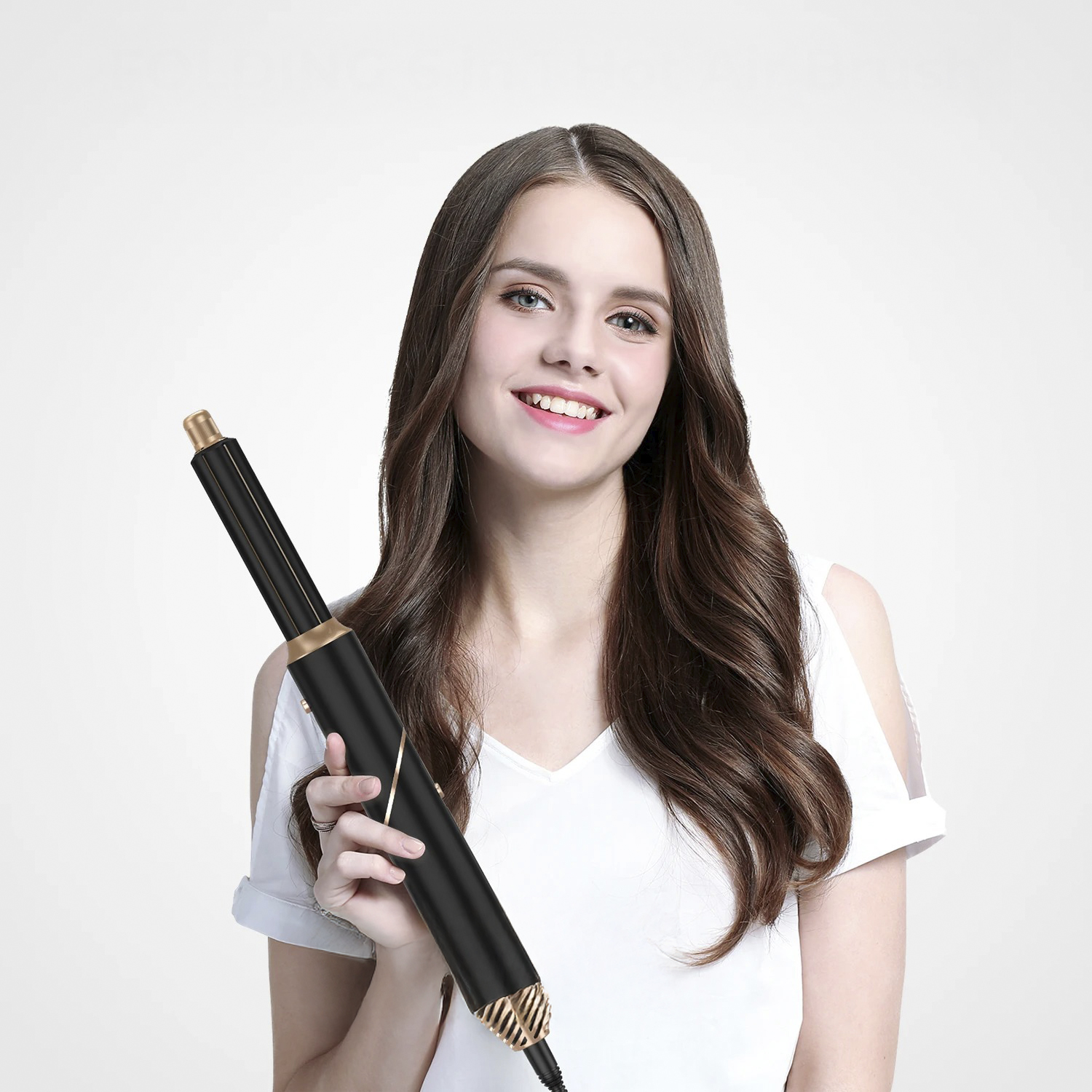 Eine lächelnde Frau hält einen schwarz-goldenen Lockenstab. Sie trägt ein weißes Oberteil. Langes, braunes Haar umrahmt ihr Gesicht. Weißer Hintergrund.