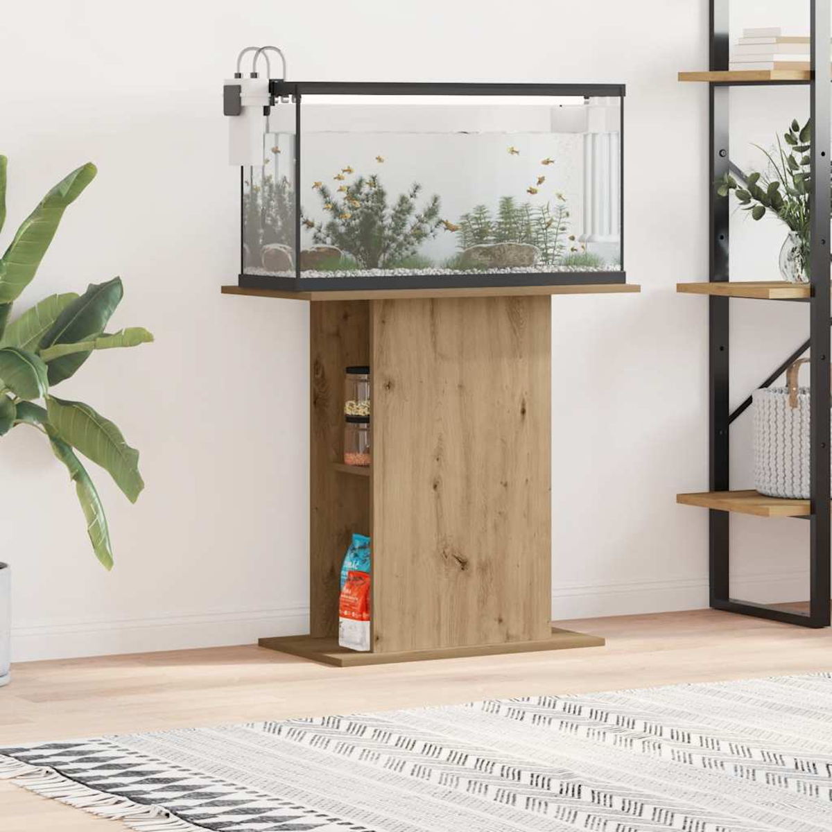 Aquarium auf Holzständer. Fische schwimmen darin. Regale, Pflanzen und ein Teppich sind im Raum vorhanden.
