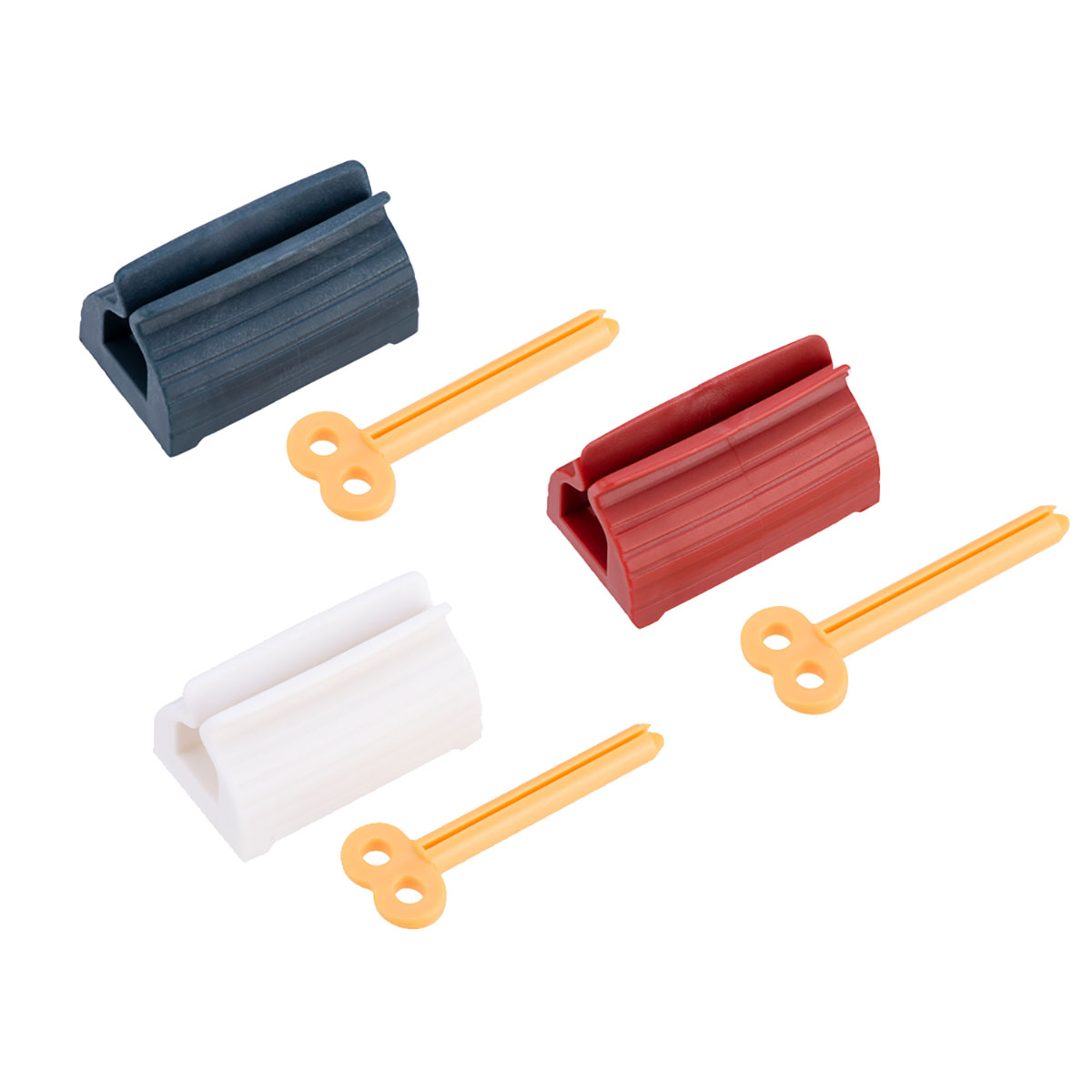 Drei farbige Zahnpasta-Tubenquetscher mit gelben Schlüsseln. Blaue, rote und weiße Quetscher sind auf weißem Hintergrund zu sehen.
