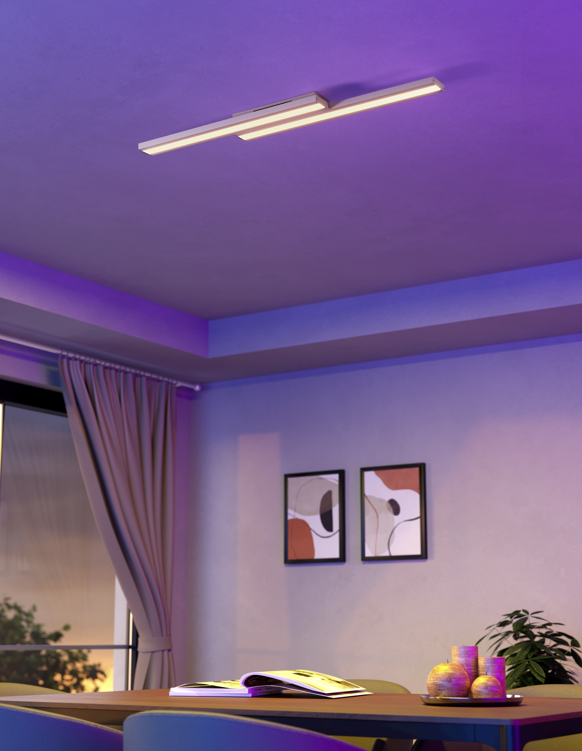 Una habitación con luz de techo, mesa, cortinas, arte y plantas. Luz ambiental morada y rosa. Un libro abierto en la mesa.