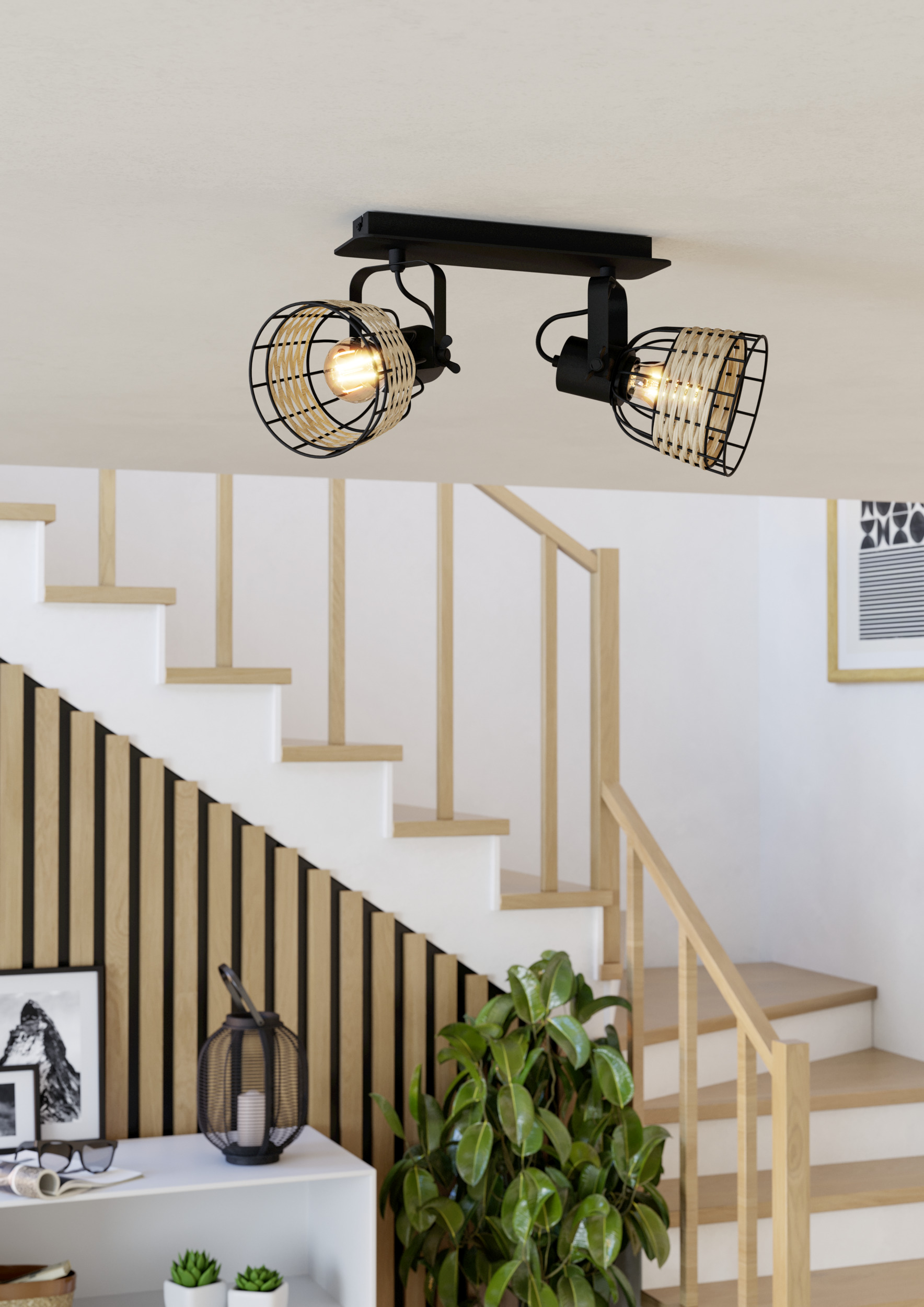 Plafonnier avec deux lampes. Escalier, mur en bois et plantes sont visibles en arrière-plan.