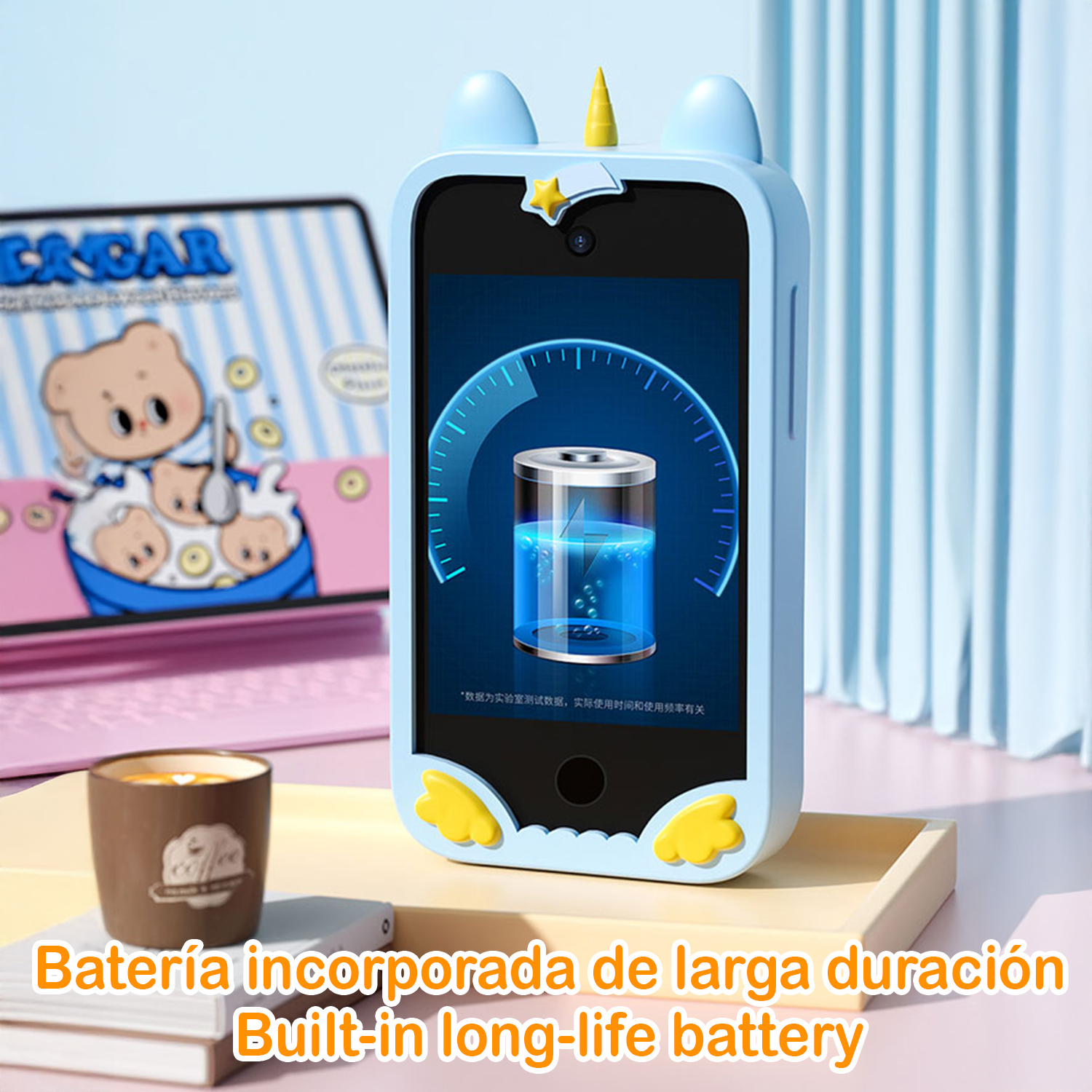 Un telefono blu con un design a unicorno mostra un'icona della batteria. Un laptop con un orso dei cartoni animati è sullo sfondo.