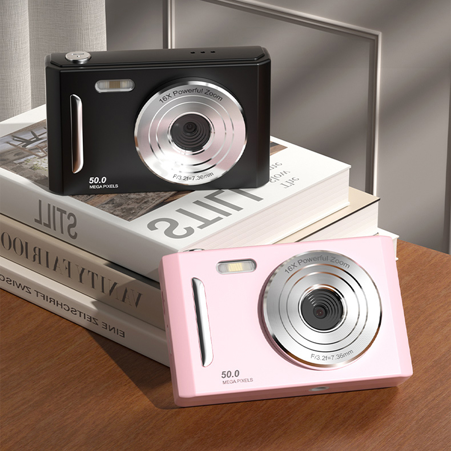 Due fotocamere digitali, nera e rosa, su libri. Quella nera sopra. Entrambe hanno lo zoom e sono su un tavolo di legno.