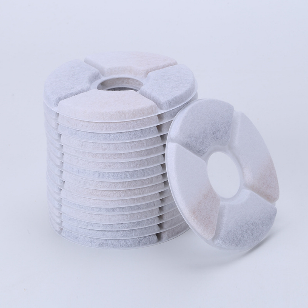 Ein Stapel Ersatzfilter für Katzenwasser. Jeder Filter ist kreisförmig mit unterschiedlich farbigen Segmenten. Ein Filter ist separat.
