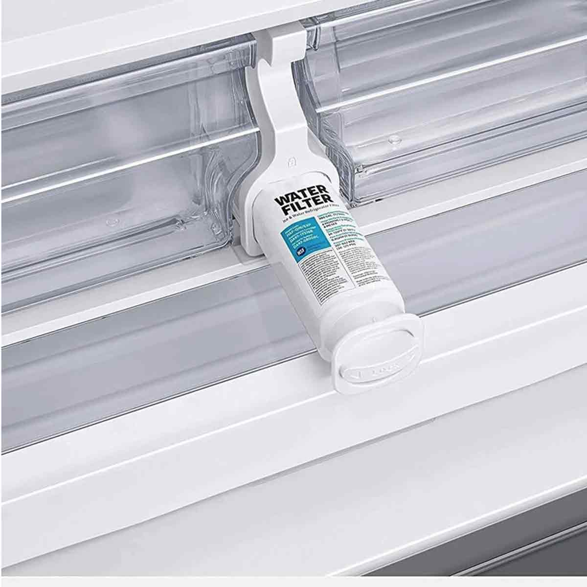 Ein weißer Wasserfilter ist in einem Kühlschrank installiert. Der Filter ist mit 'Water Filter' beschriftet. Der Hintergrund ist ein sauberer, weißer Kühlschrank.