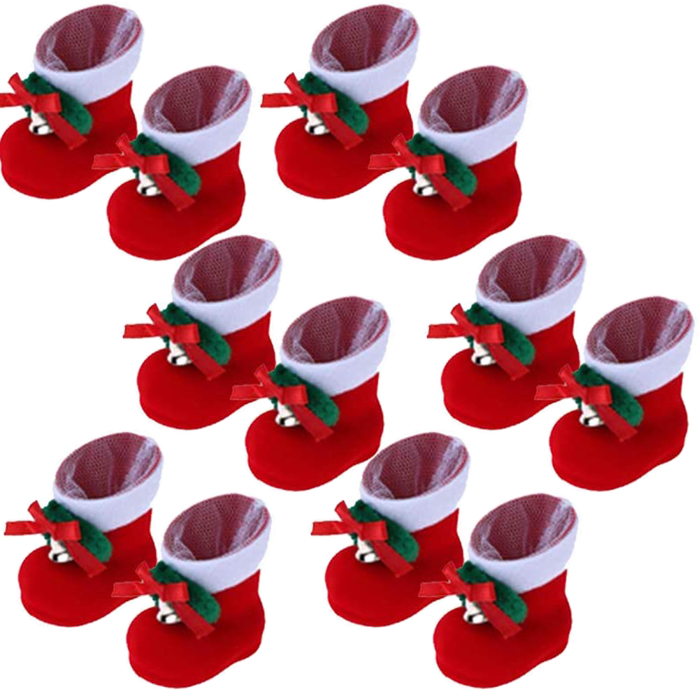 Rote Weihnachtsstiefel mit weißen Oberteilen, grünen Blättern und roten Schleifen. Mehrere Stiefel, angeordnet auf weißem Hintergrund.