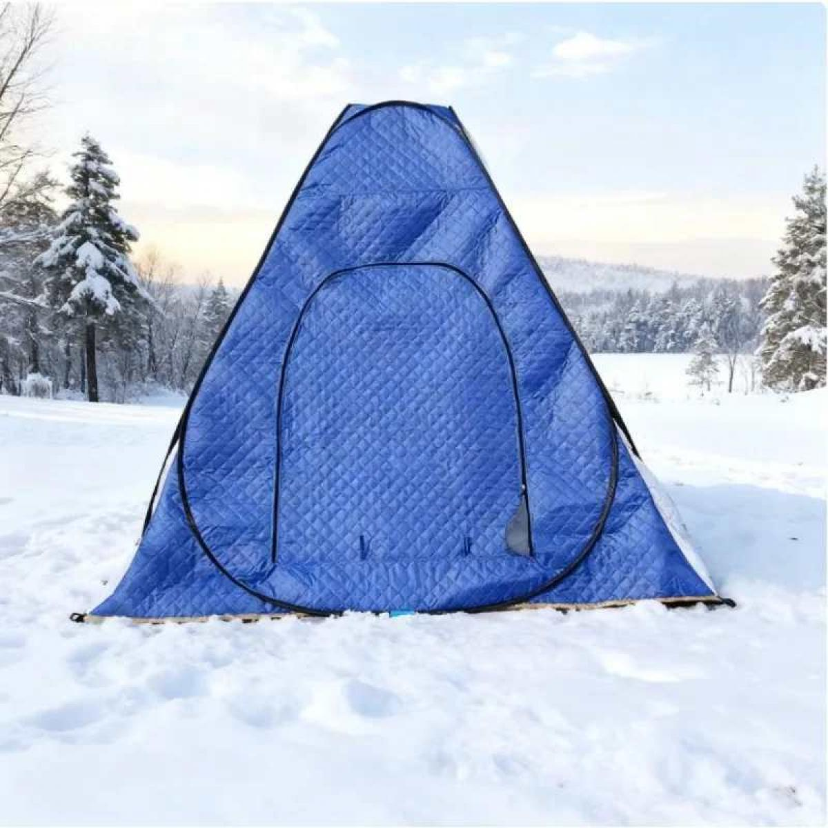 Ein blaues, gestepptes Zelt steht im Schnee. Im Hintergrund sind Wald und Berge. Der Himmel ist blau mit ein paar Wolken.