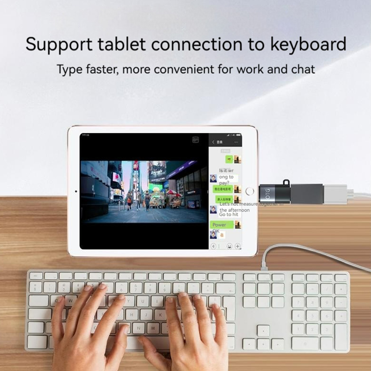 Tablet mit Tastatur verbunden. Hände tippen. Der Tablet-Bildschirm zeigt eine Stadtszene und eine Chat-App. USB-Stick ist angeschlossen.