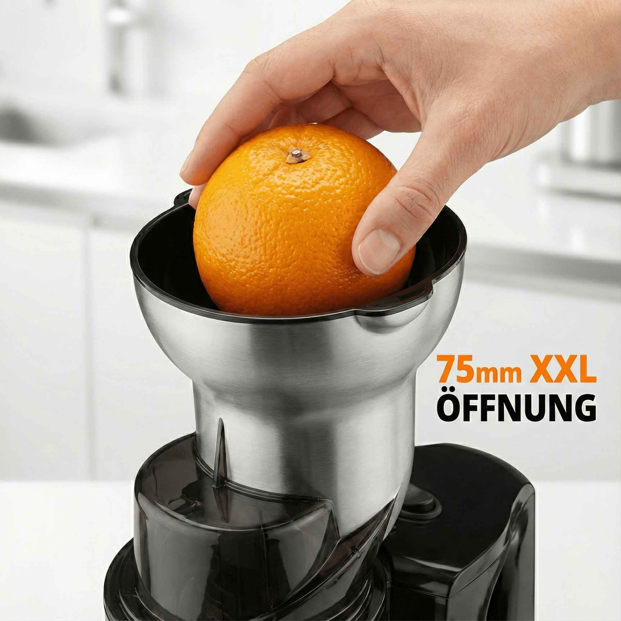 Hand, die eine Orange in eine Saftpresse legt. Die Saftpresse ist silber und schwarz, mit Text '75mm XXL Öffnung'.