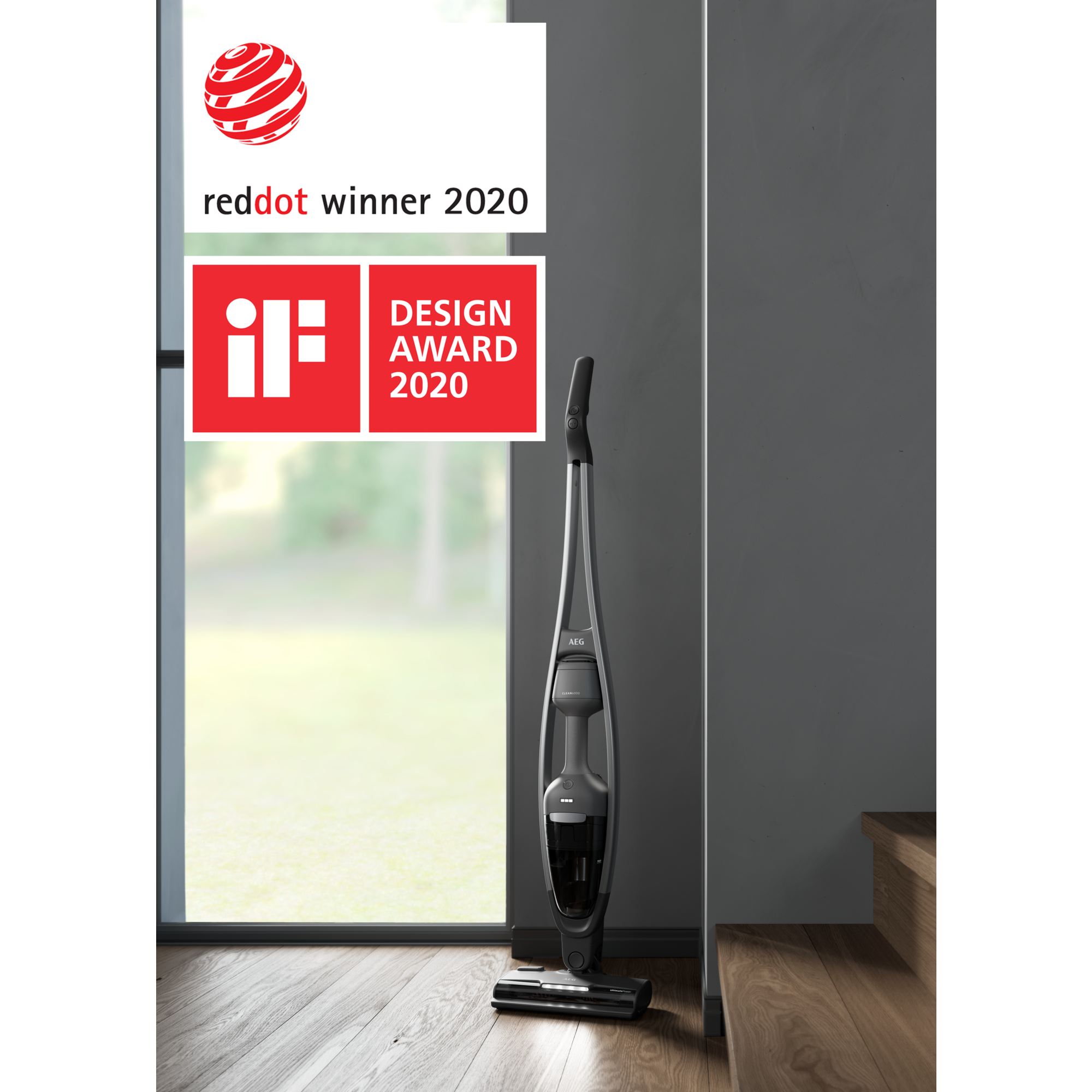 Una aspiradora AEG gris se encuentra cerca de una ventana y una pared. Son visibles los premios Red Dot e iF Design.