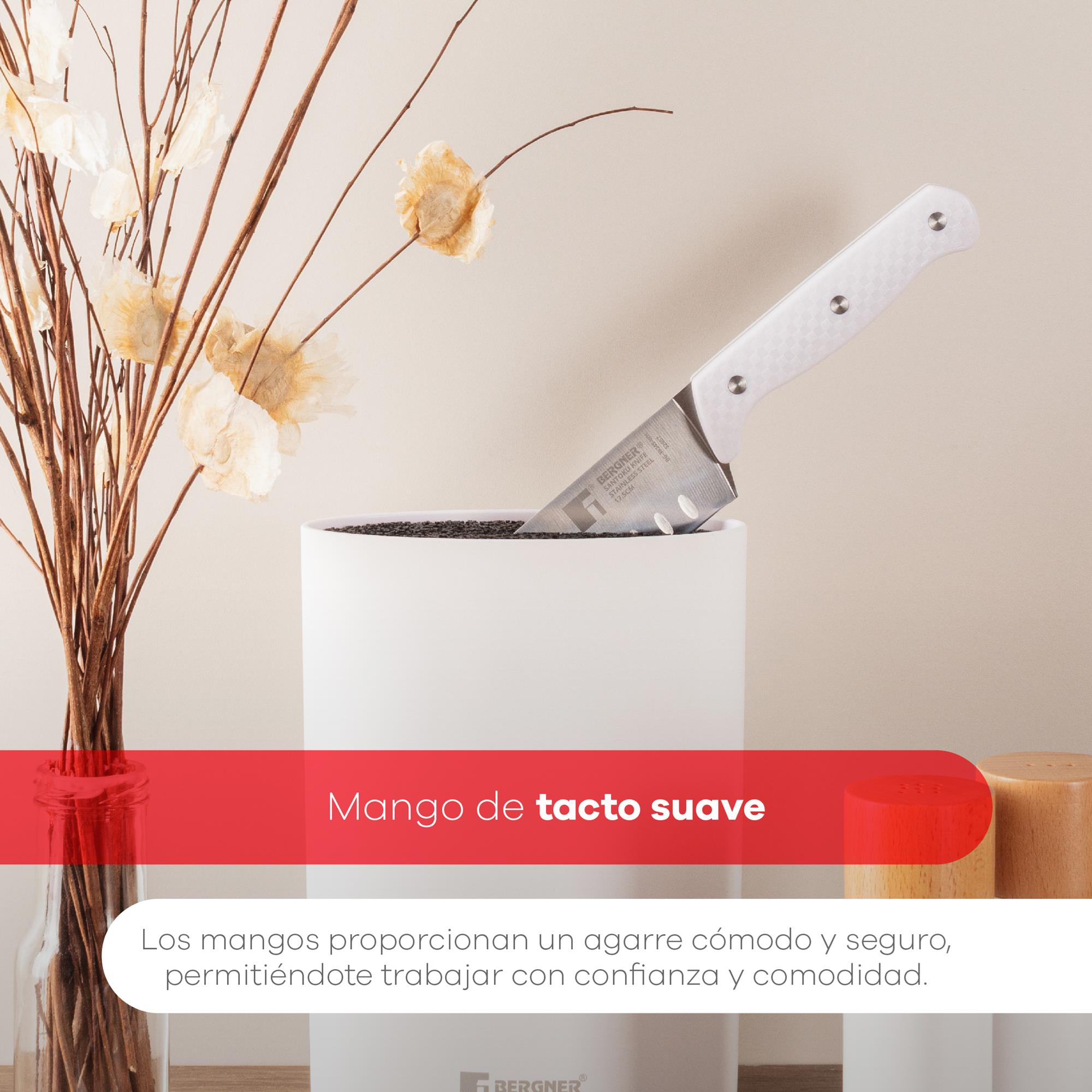 Un cuchillo blanco está en una maceta blanca. Plantas secas a la izquierda. El fondo es de color canela claro.