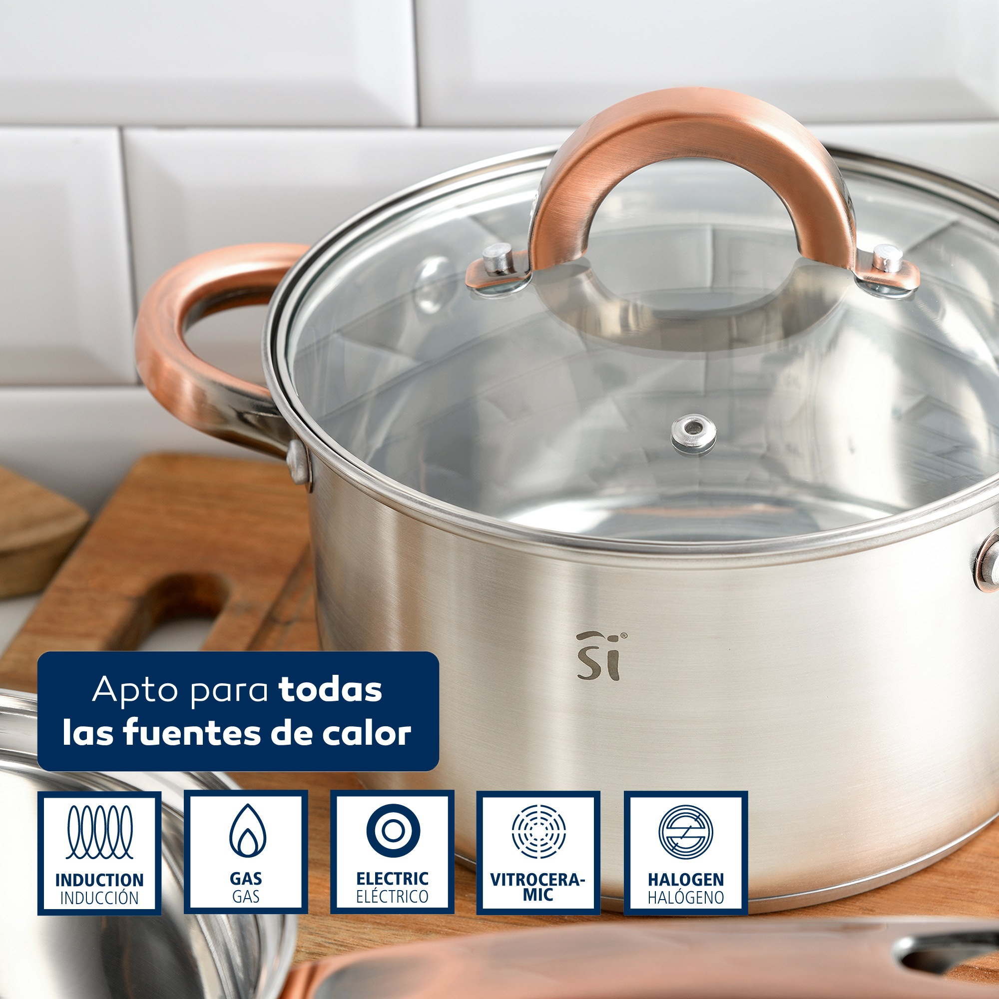 Olla de acero inoxidable con asas de cobre y tapa de vidrio. Incluye iconos para diferentes fuentes de calor.