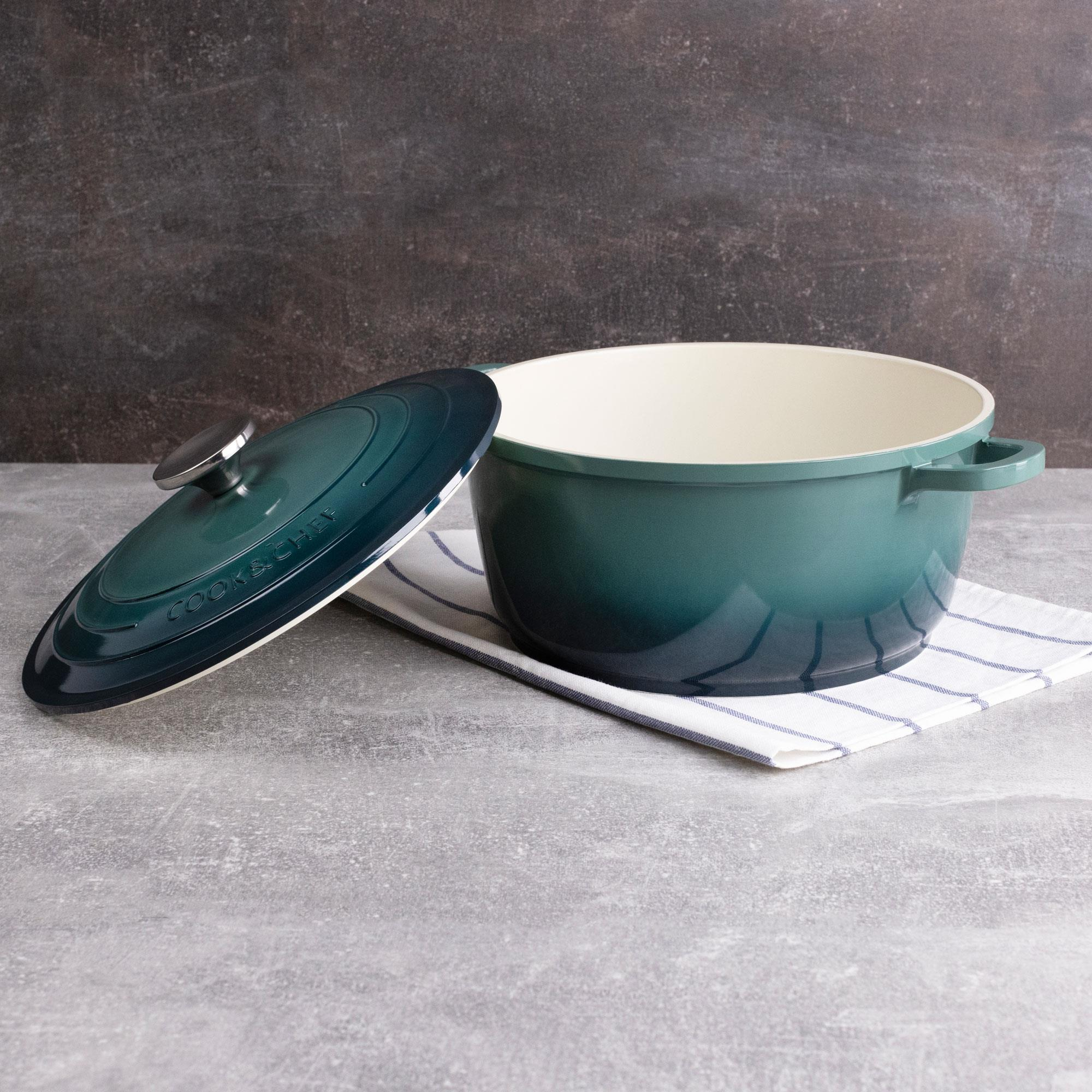 Olla verde con tapa sobre tela a rayas blancas y azules. Fondo gris.