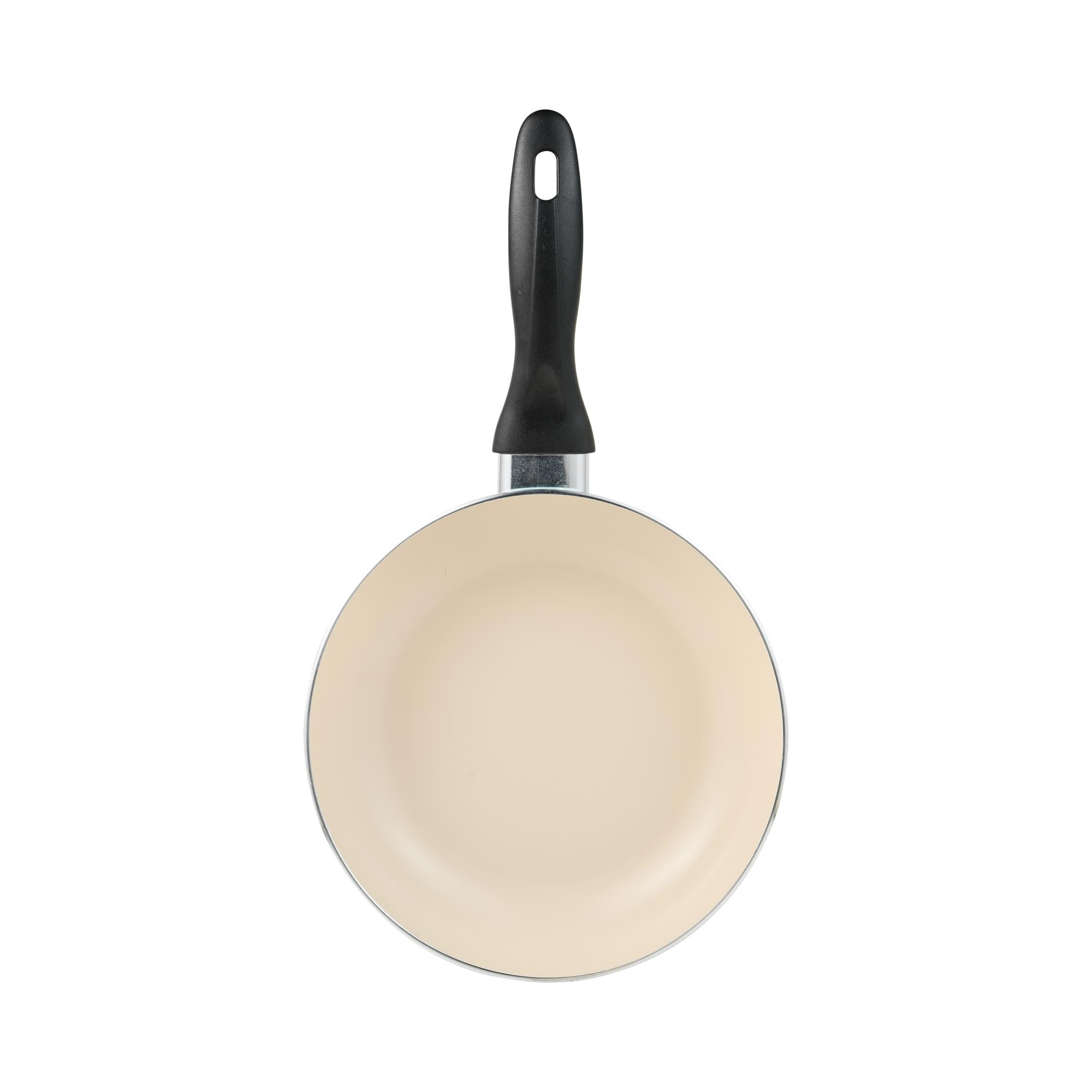 Una sartén beige con mango negro centrada en fondo blanco. La sartén es redonda.