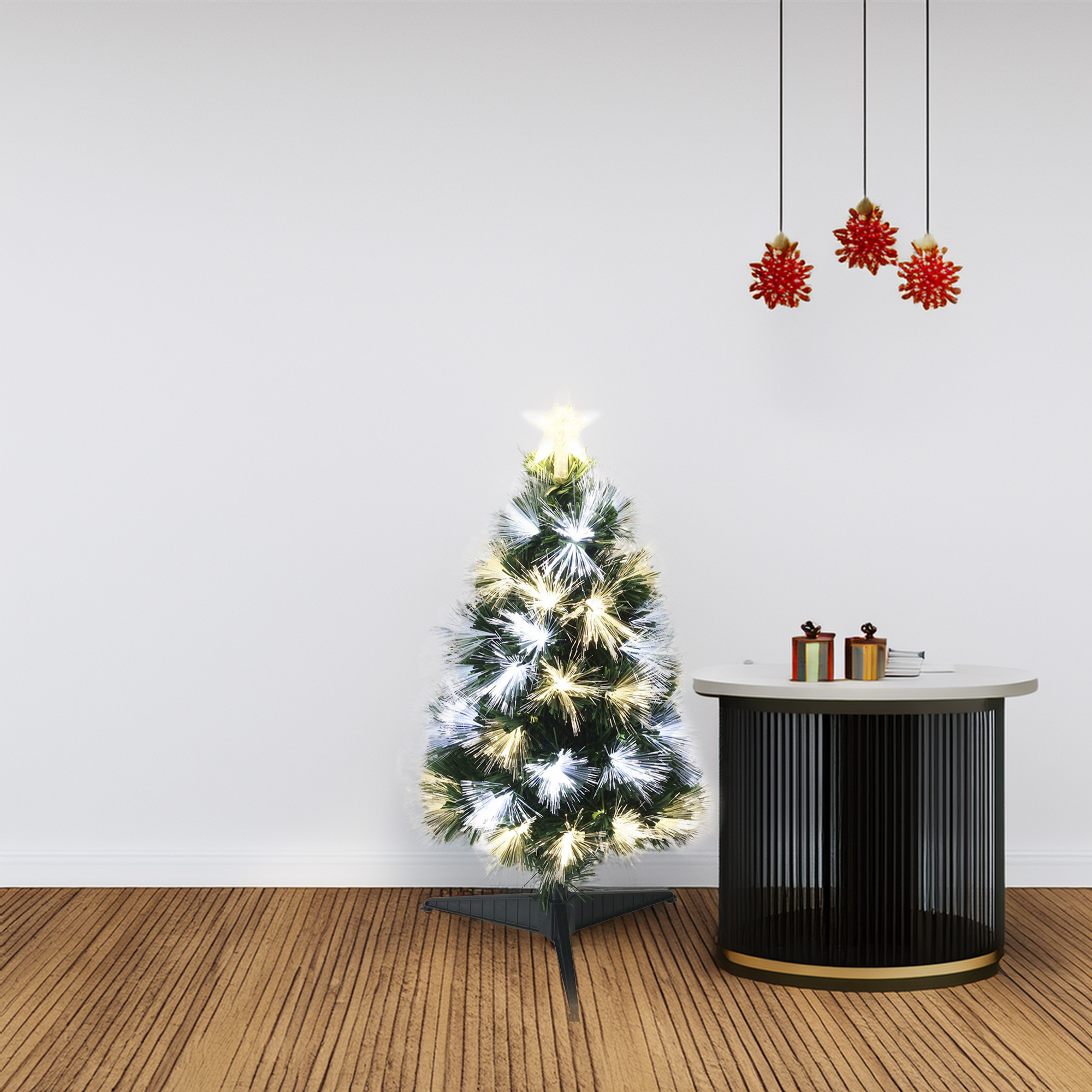 Un árbol de Navidad iluminado con estrella, regalos sobre una mesa y adornos colgantes sobre piso de madera.
