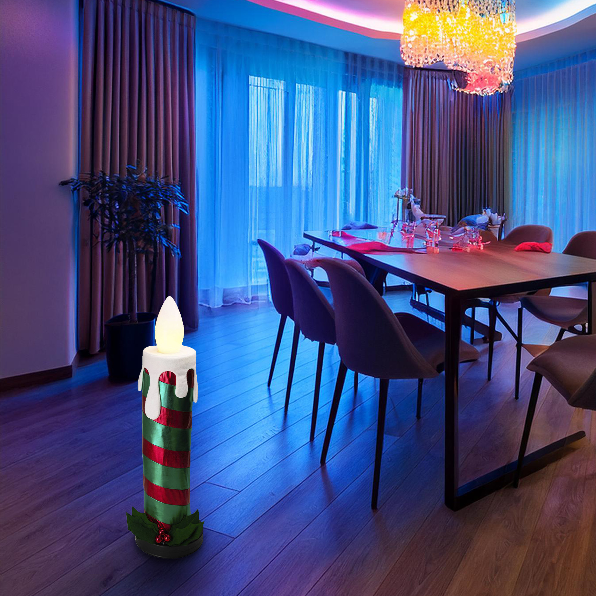 Una vela decorativa está en un comedor. Tiene rayas rojas y verdes. Una lámpara de araña cuelga sobre una mesa.