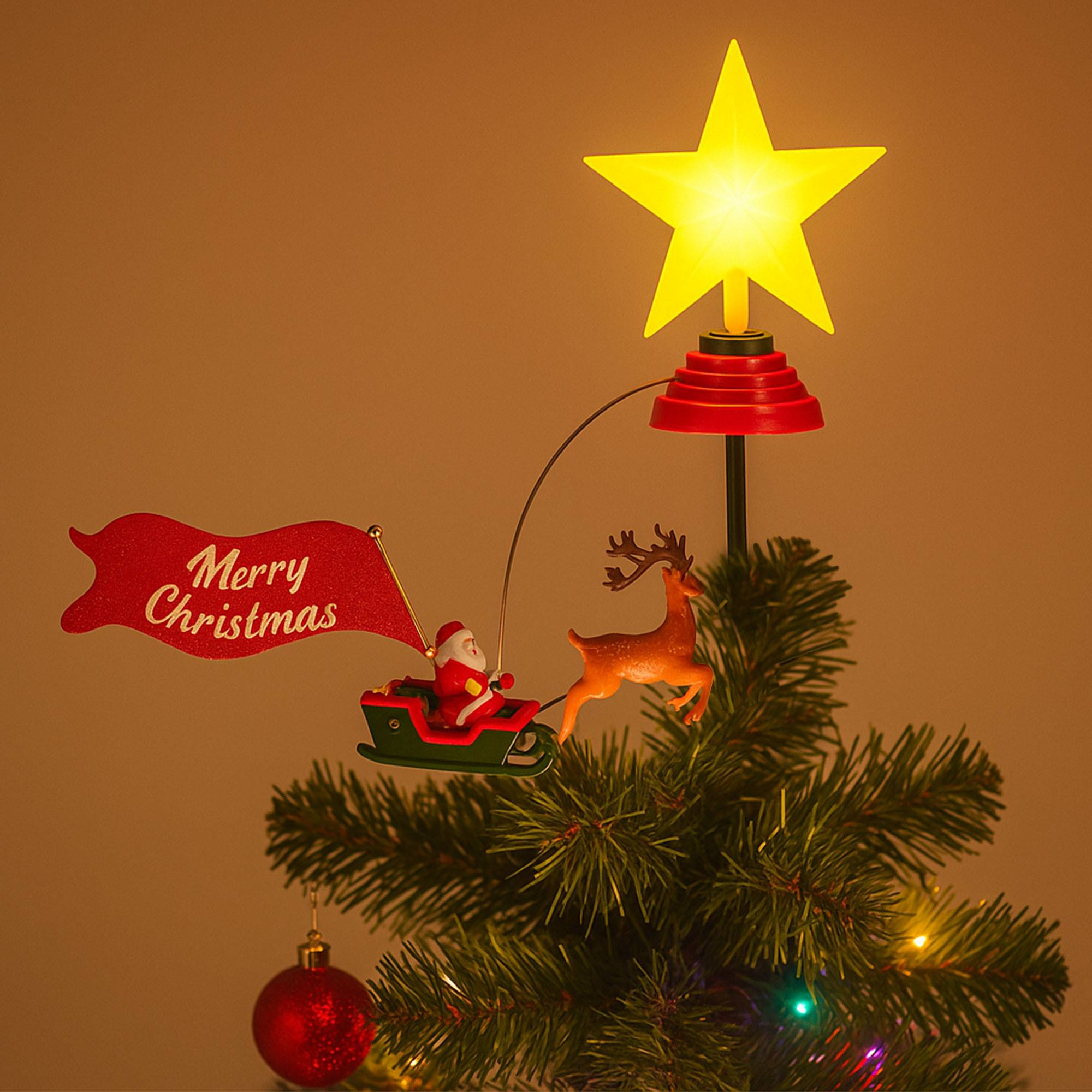 Adorno de árbol de Navidad con Papá Noel en trineo, un reno y una estrella. El adorno está en un árbol de Navidad.