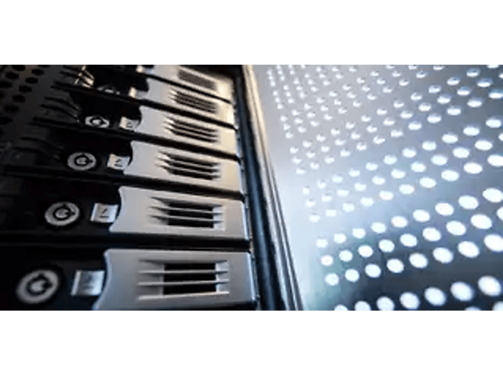 Szafa serwerowa z dyskami twardymi. Srebrny i czarny sprzęt. Perforowany panel boczny z małymi otworami.