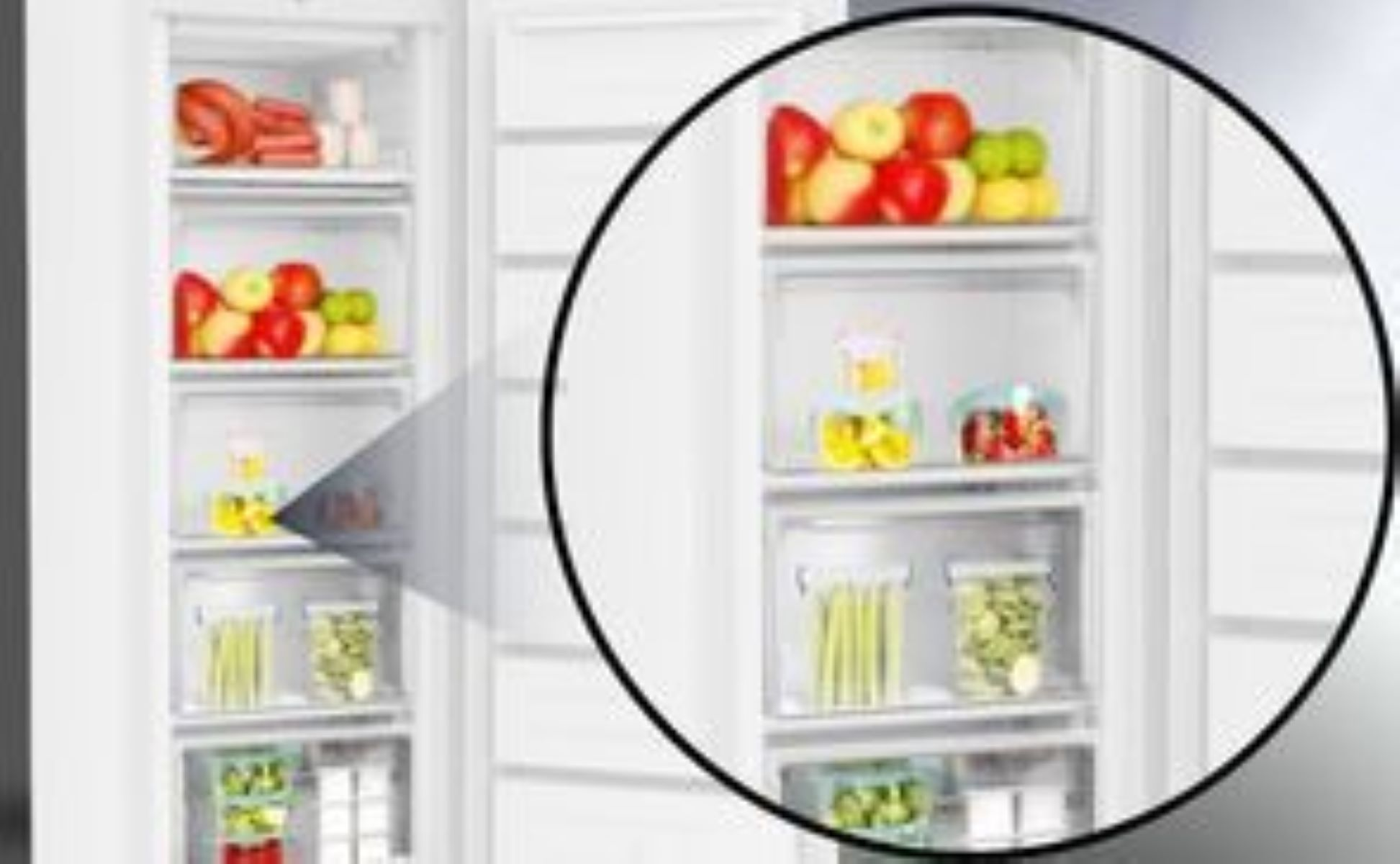 Kühlschrankinnenraum. Äpfel, Zitronen und Gemüse sind in durchsichtigen Schubladen gelagert. Fleisch und andere Artikel sind ebenfalls sichtbar.
