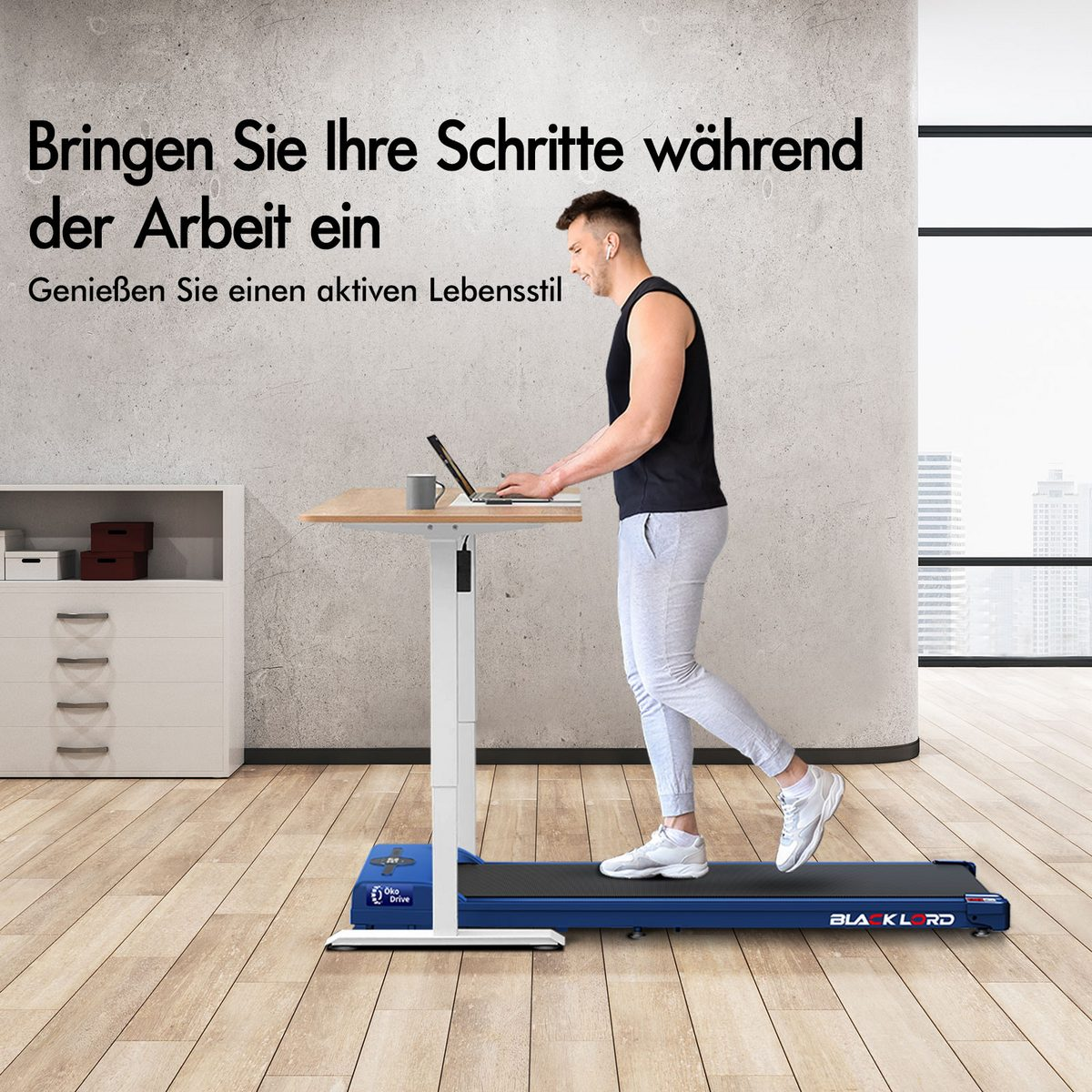 Ein Mann geht in einem Büro auf einem Laufband-Schreibtisch. Er trägt ein schwarzes Tanktop und hellgraue Hosen. Ein Laptop und eine Tasse stehen auf dem Schreibtisch.