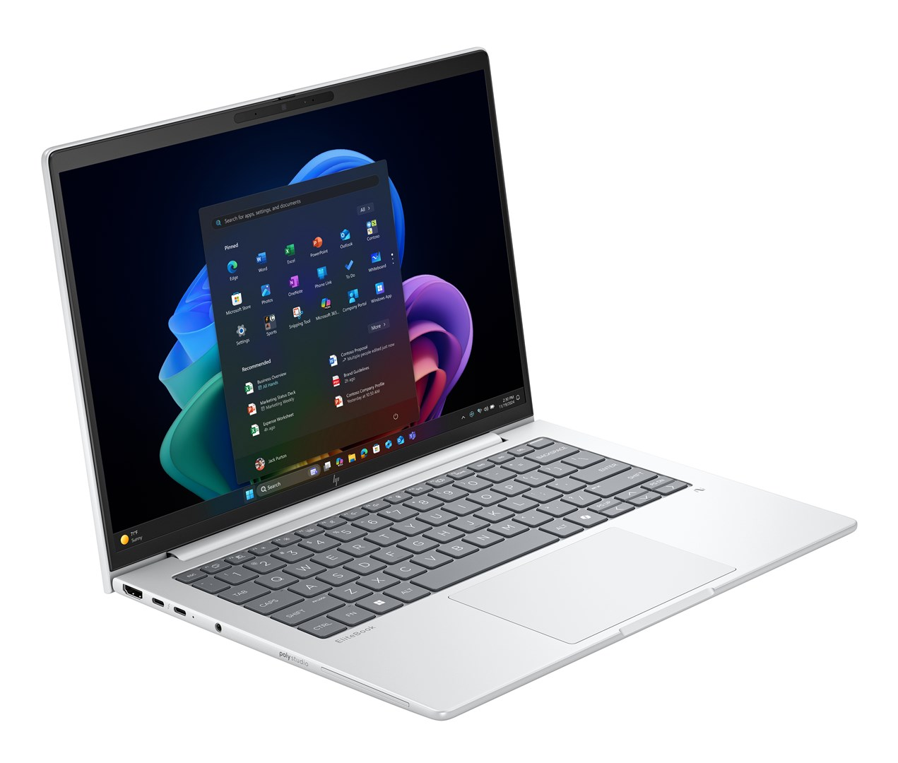 Srebrny laptop jest otwarty, wyświetlając interfejs Windows. Ekran pokazuje ikony aplikacji i menu start. Klawiatura i touchpad widoczne.