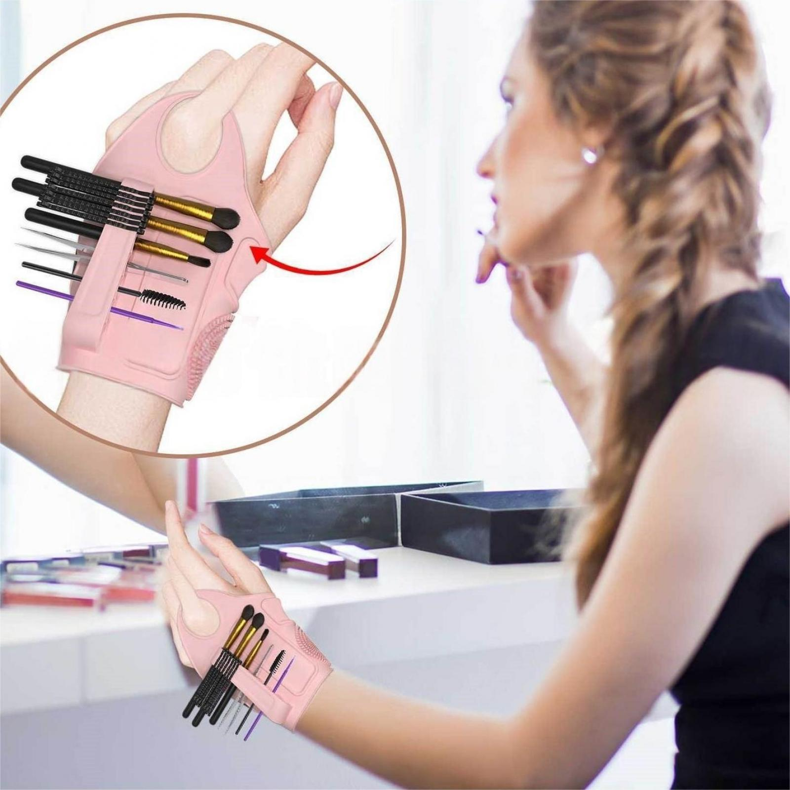 Eine Frau benutzt Make-up-Pinsel aus einem rosa Handschuh. Eine andere Hand hält einen ähnlichen Handschuh. Hintergrund: Schminktisch und Frau.