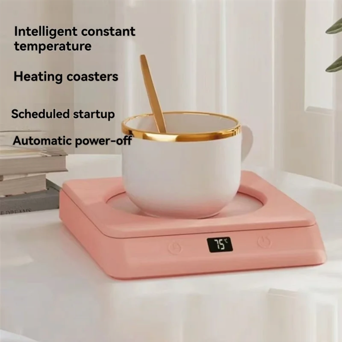 Eine weiße Tasse mit Goldrand und Löffel steht auf einem rosa Heizuntersetzer. Der Untersetzer zeigt 75 Grad an.