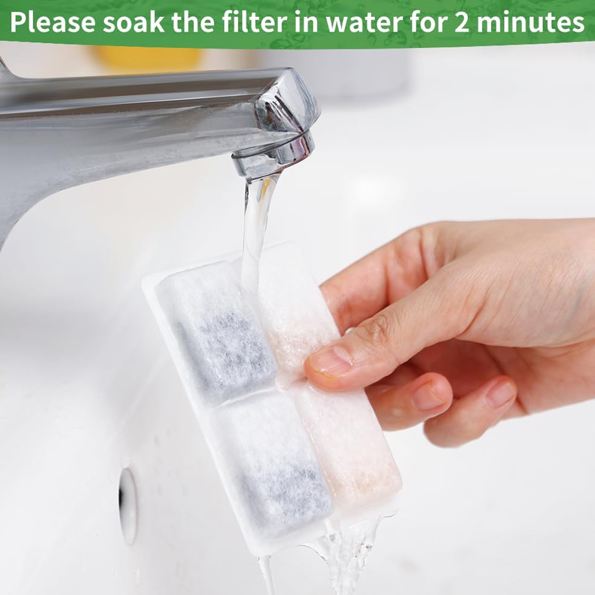 Eine Hand hält einen Filter unter fließendem Wasser aus einem Wasserhahn. Der Filter ist weiß mit dunklen und hellen Abschnitten.