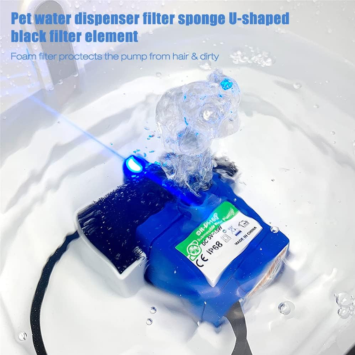 Blauer Haustier-Wasserspender mit schwarzem Filterschwamm, Wasser spritzt nach oben. Text auf dem Gerät: DC 5V-15W. Wasser in einem weißen Becken.