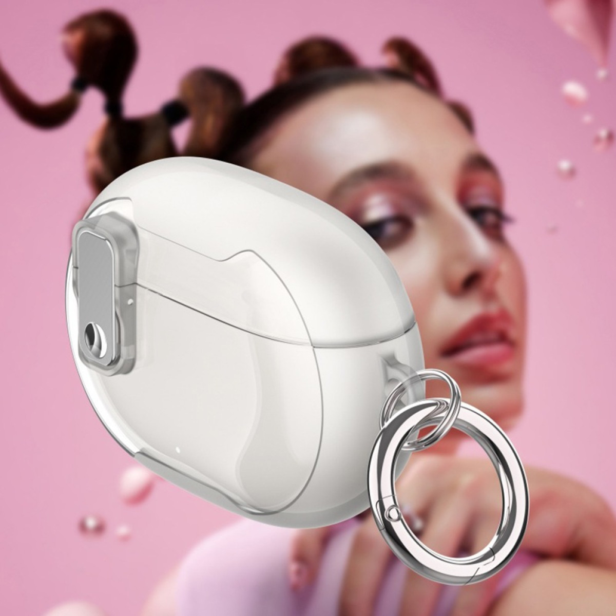A clear, oval-shaped case with a silver ring hangs in front of a woman. The background is pink, with the woman out of focus.