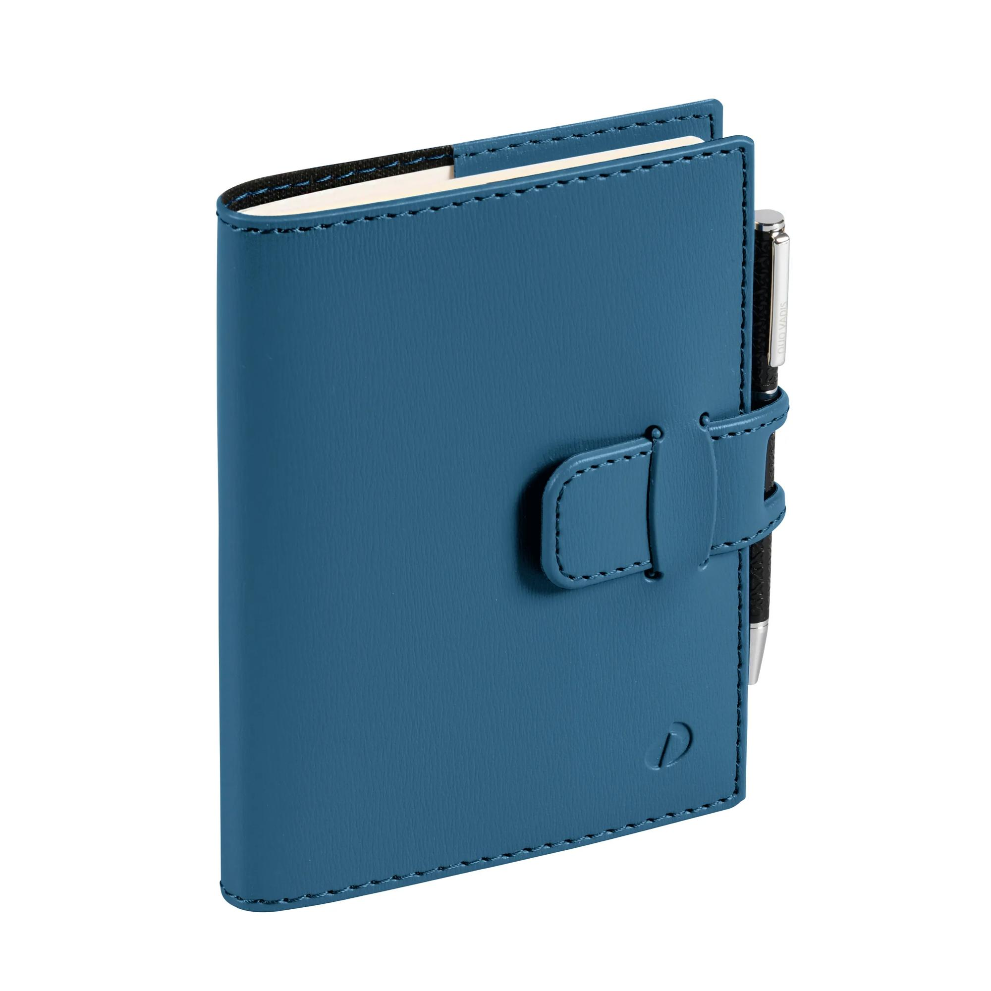 Un cuaderno de cuero color turquesa con un bolígrafo insertado. Tiene un cierre y un logotipo 'D'. El fondo es blanco.