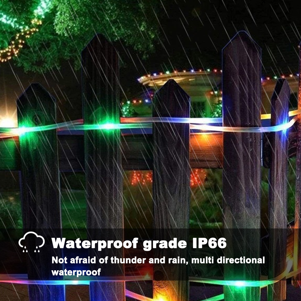 Ein Holzzaun mit bunten Lichtern im Regen. Grüne, blaue und orangefarbene Lichter sind sichtbar. Der Text lautet 'Wasserdichtigkeit IP66'.