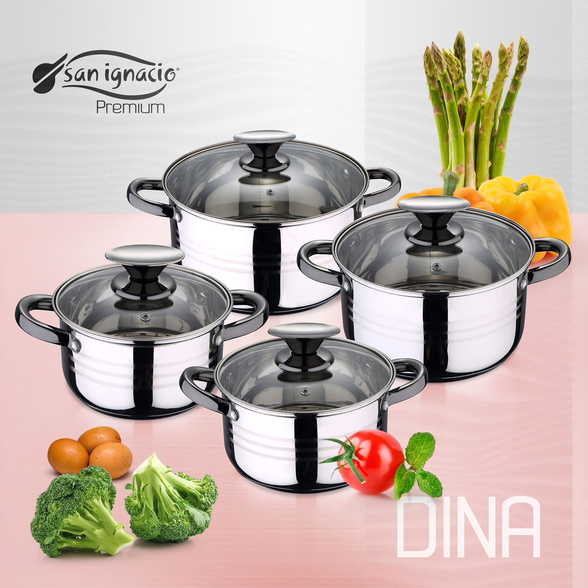 Cuatro ollas de acero inoxidable con tapas de vidrio, verduras como espárragos, tomate, huevos y brócoli sobre fondo rosa.