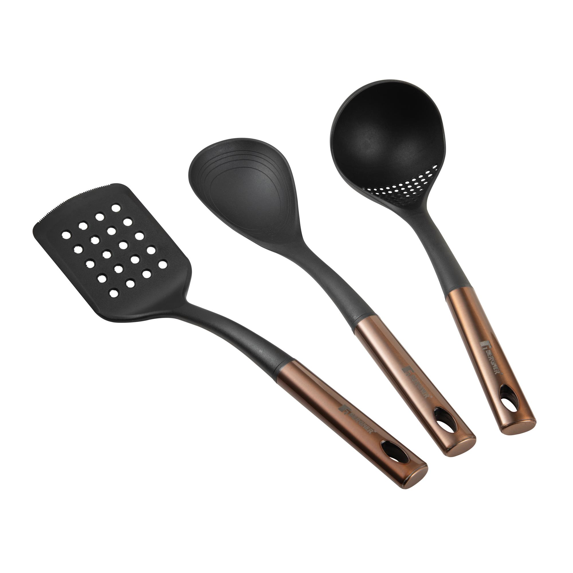 Tres utensilios de cocina negros: una espátula ranurada, una cuchara y un cucharón ranurado. Todos tienen mangos de bronce.