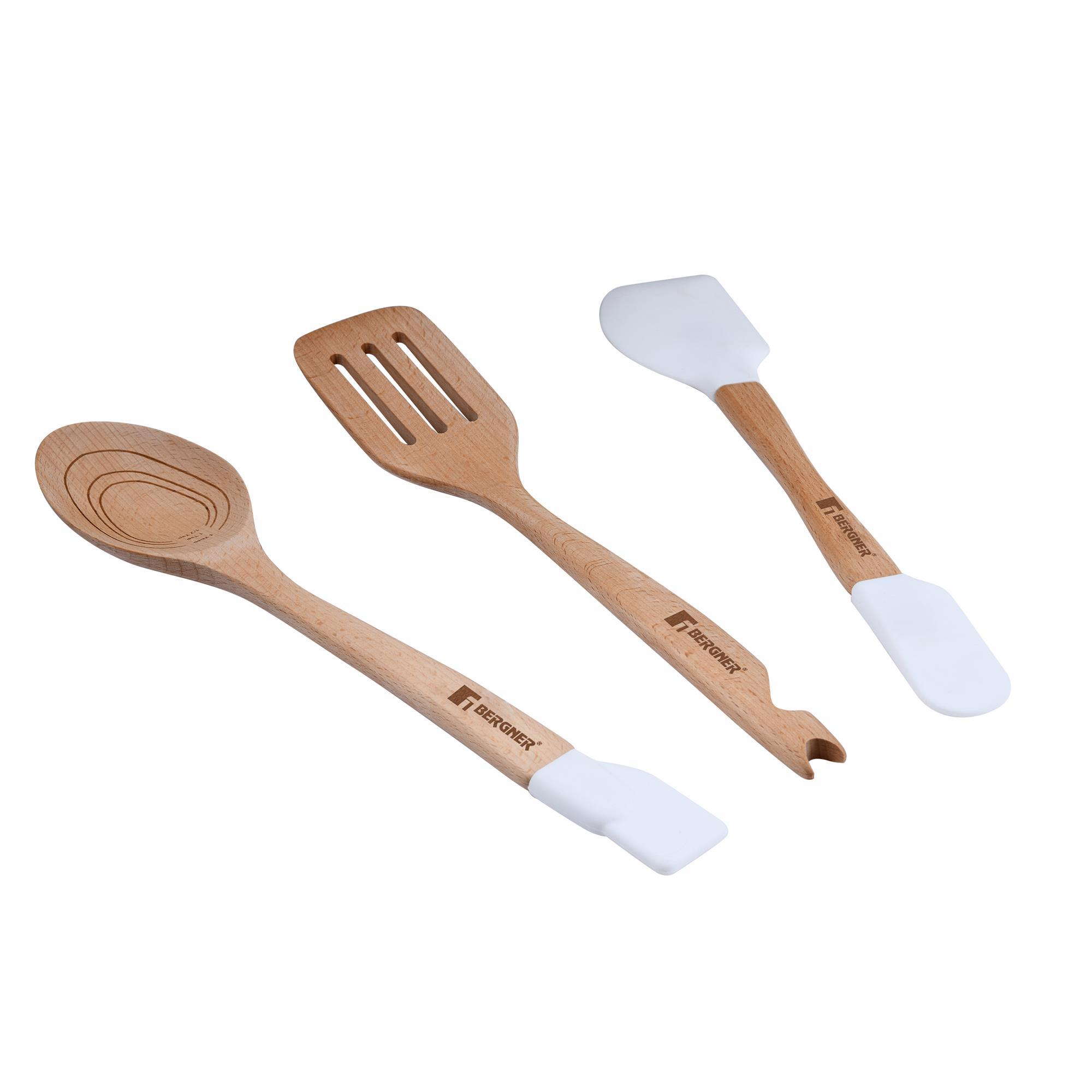 Tres utensilios de cocina de madera: una cuchara, una espátula ranurada y una espátula con cabezal de silicona blanca. Todos tienen el logo 'BERGNER'.
