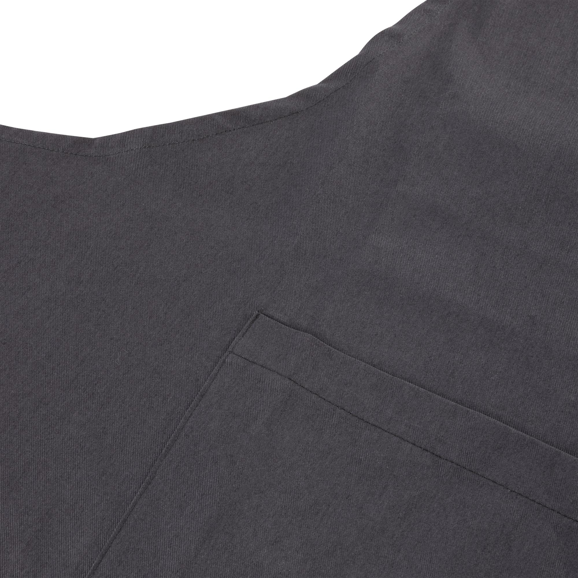 Primer plano de una tela gris oscuro con un bolsillo. La tela tiene una apariencia texturizada y está bien iluminada.