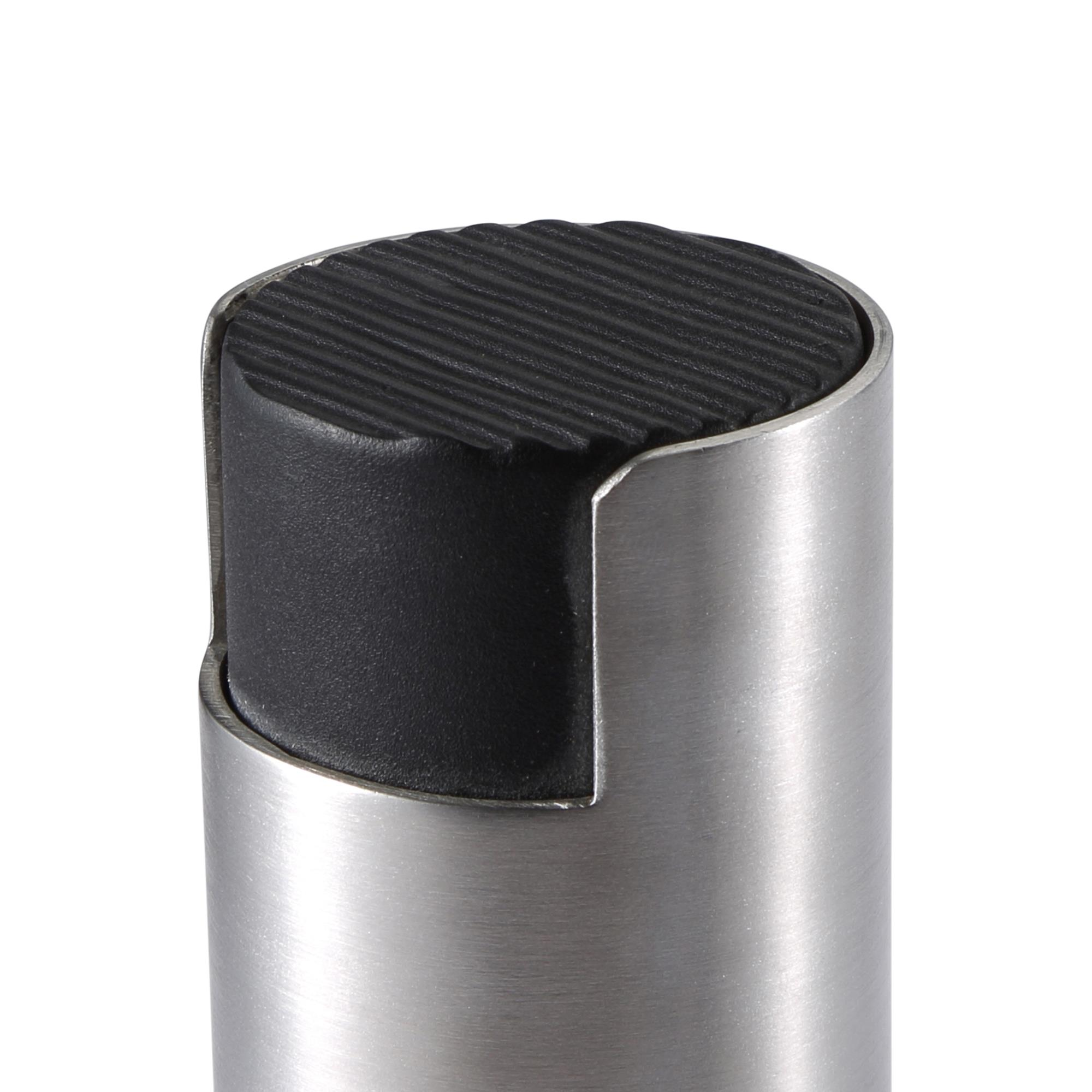 Primer plano de un tope de puerta. Tiene una parte superior de goma negra y acanalada y una base de metal cilíndrica plateada.