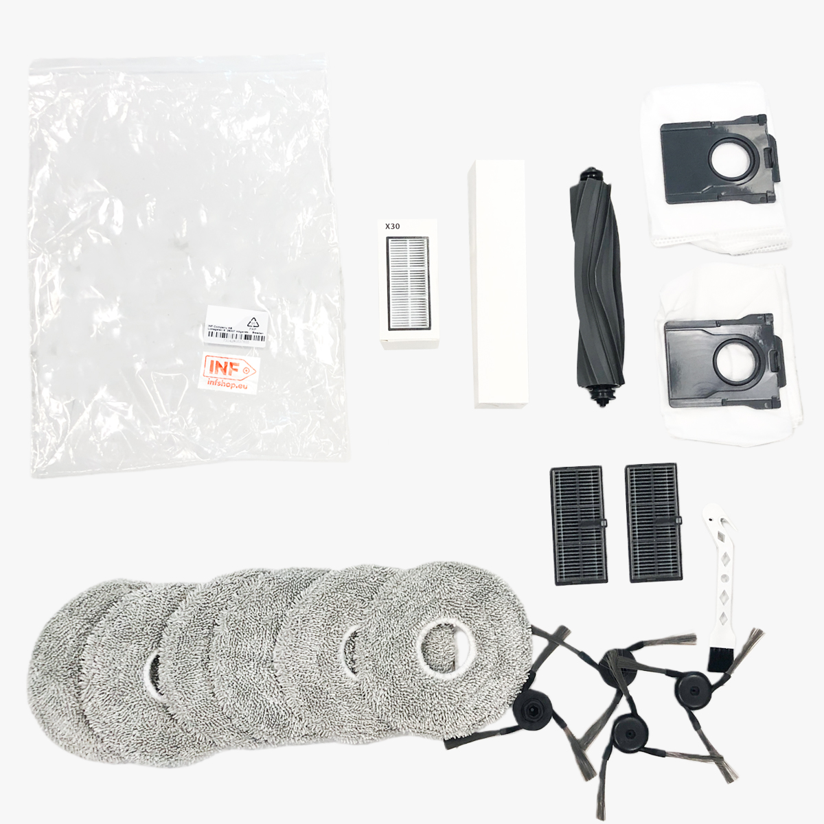 Akcesoria do odkurzacza robota: filtr, szczotki, pady czyszczące i worki na kurz ułożone na białej powierzchni.