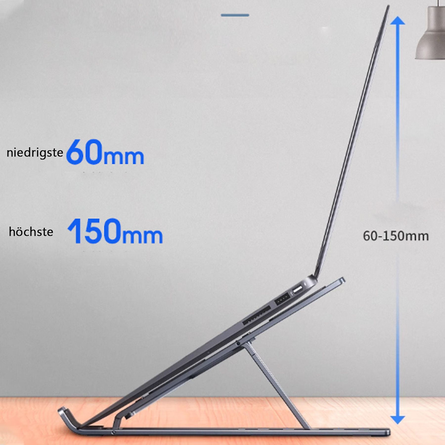 Laptop auf einem Ständer, Seitenansicht. Ständer ist verstellbar, Abmessungen sind 60-150mm. Hintergrund ist eine hellgraue Wand.