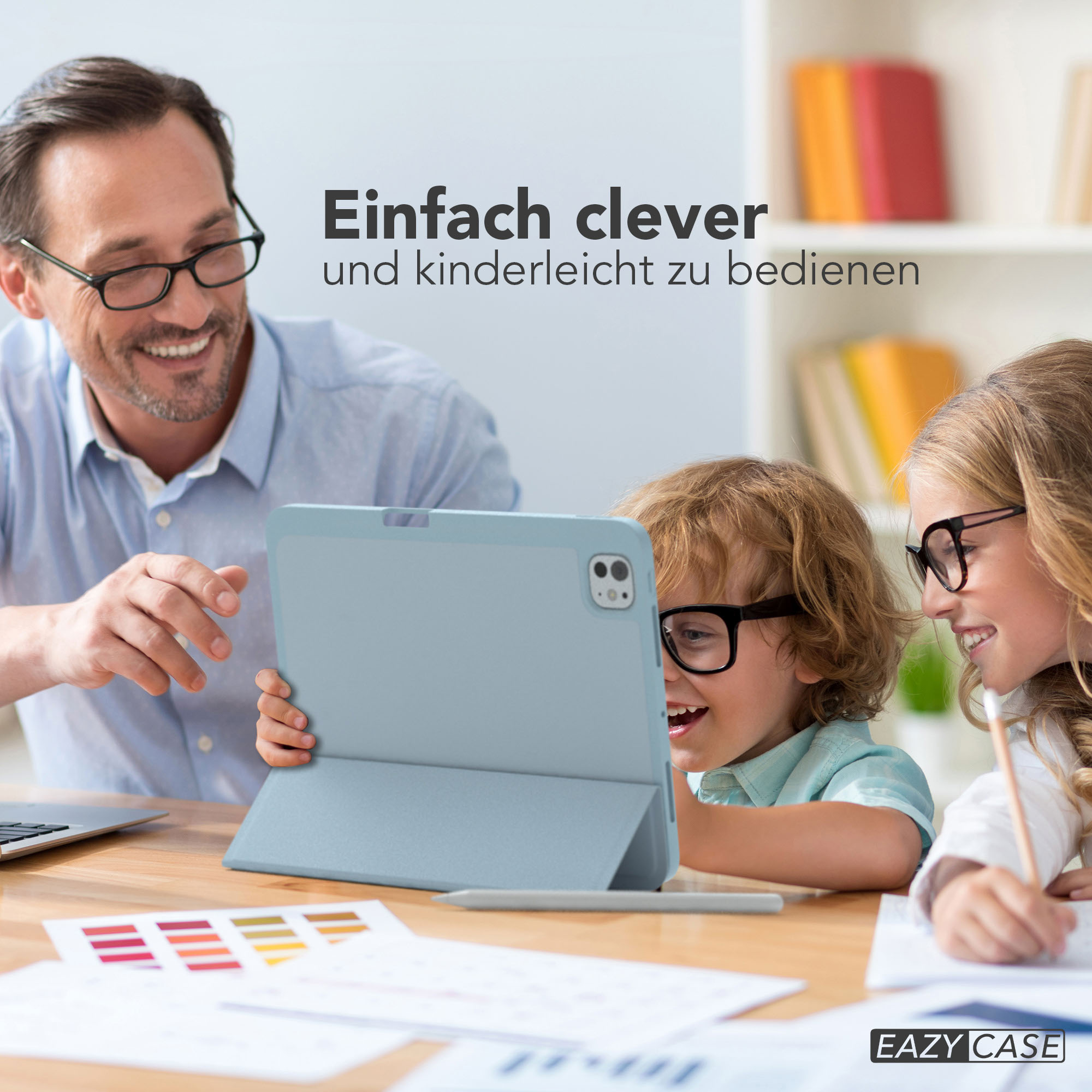 Ein Mann und zwei Kinder schauen auf ein Tablet. Die Kinder tragen Brillen. Auf dem Tisch befinden sich Farbmuster.