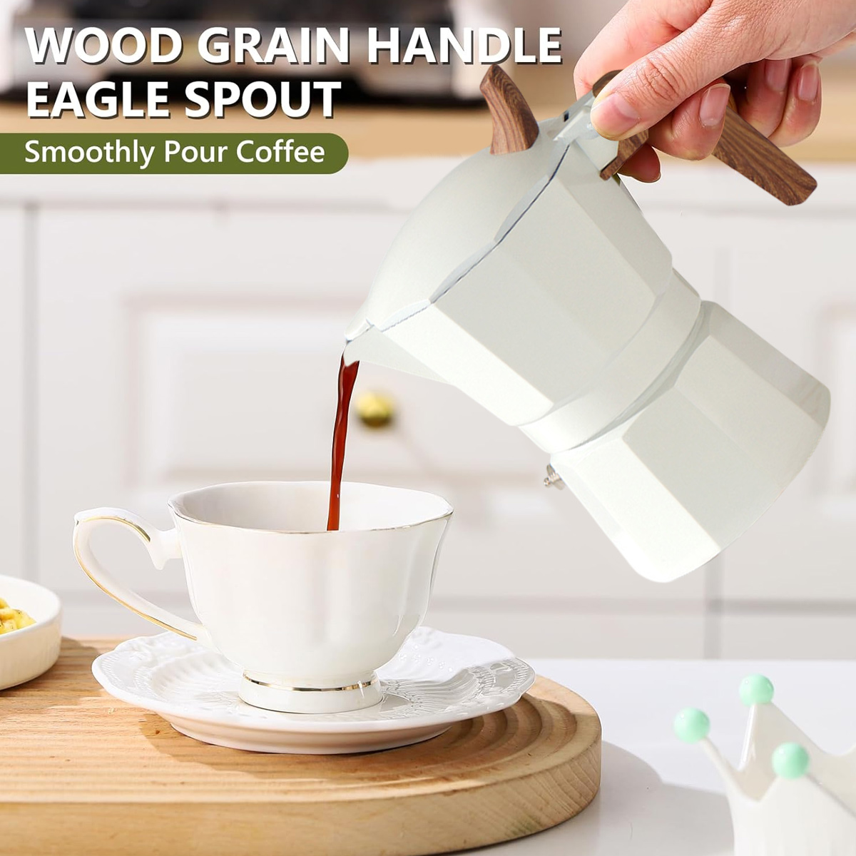 Eine weiße Kaffeekanne gießt Kaffee in eine weiße Tasse auf einer Untertasse. Die Kanne hat Holzgriffe. Die Tasse hat einen Goldrand.