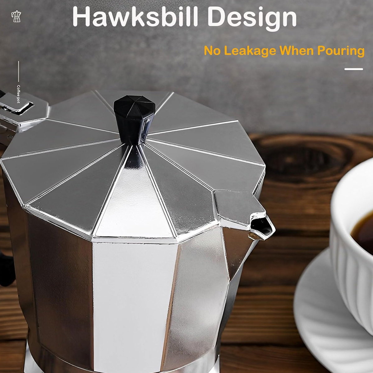 Eine silberne Kaffeekanne mit schwarzem Griff steht auf einer Holzoberfläche neben einer weißen Tasse mit Kaffee.