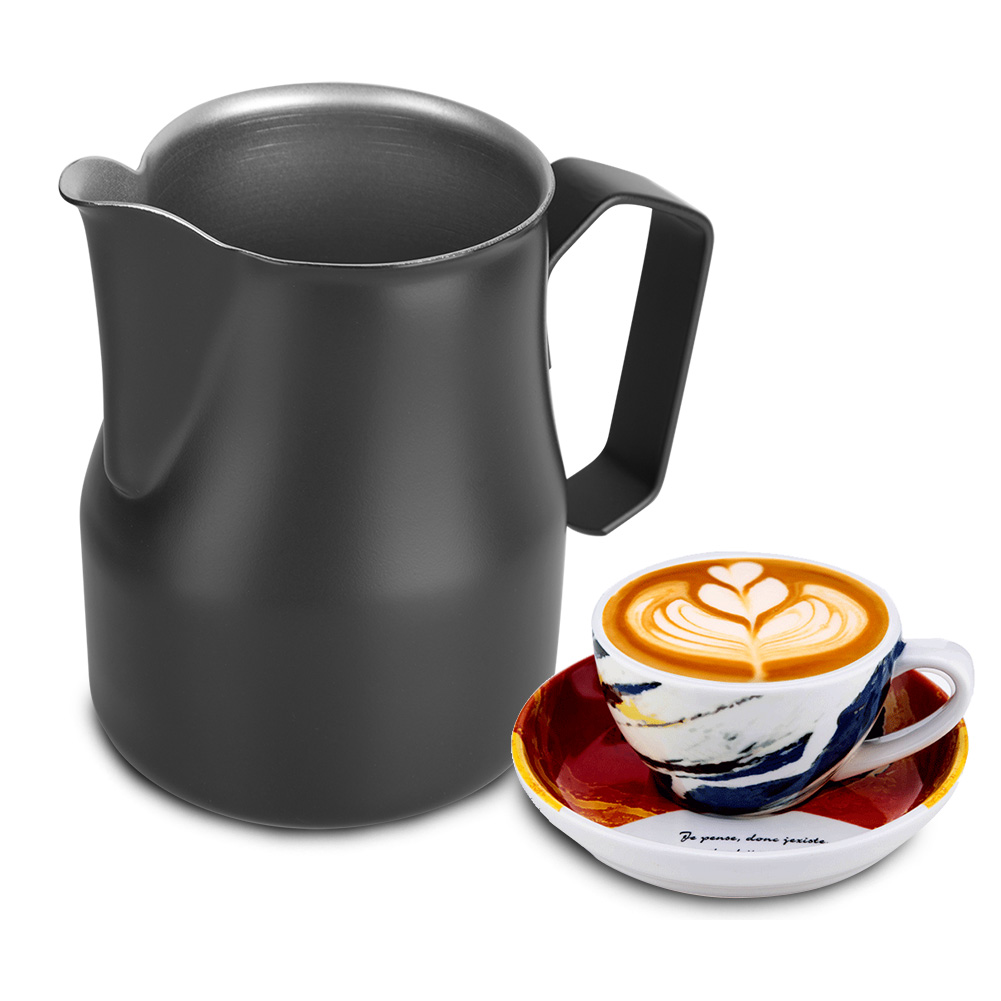 Eine schwarze Milchaufschäumkanne und eine Tasse Latte mit herzförmiger Schaumkunst auf einer Untertasse mit Text.