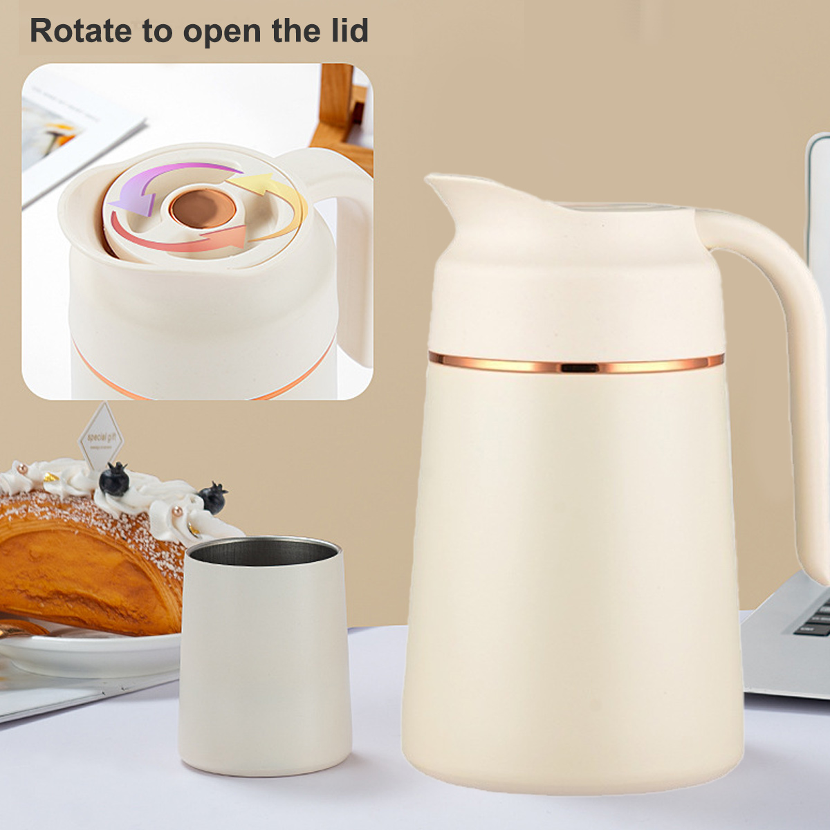 Cremefarbene Thermokaraffe und Tasse, mit Gebäck und Laptop im Hintergrund. Die Karaffe hat ein Kupferband.