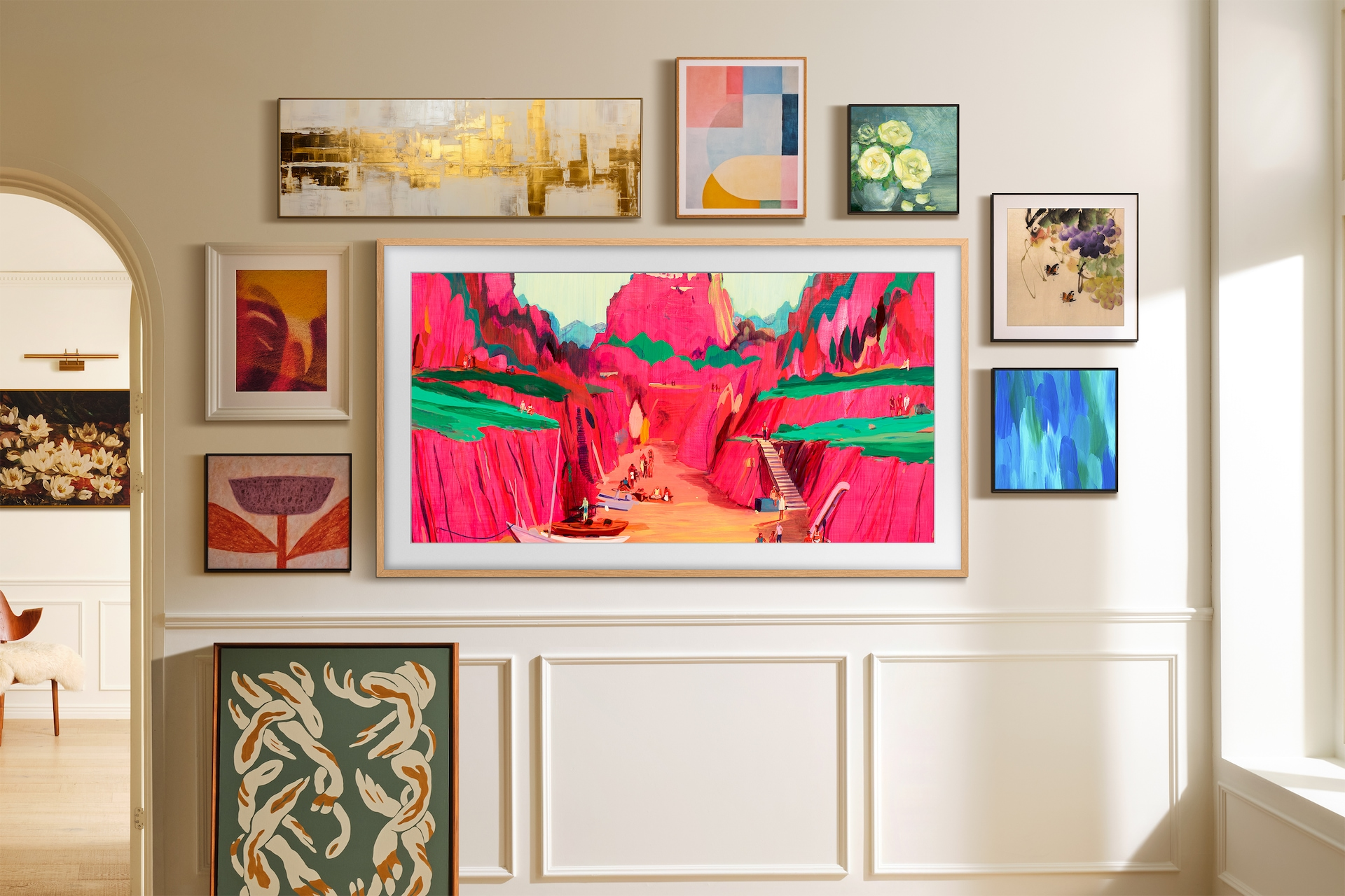 Ściana galerii prezentuje różne oprawione dzieła sztuki, w tym krajobrazy i abstrakcje. Pokój ma neutralne ściany i ościeżnicę.
